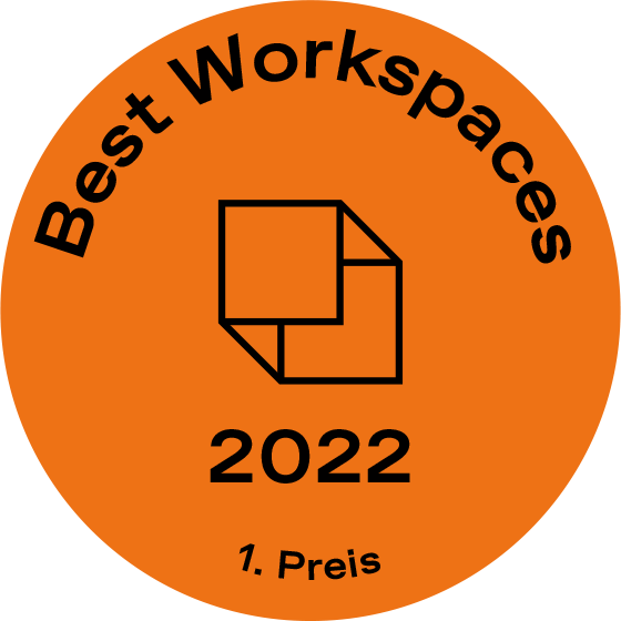 Orangefarbene runde Auszeichnungsgrafik mit Text Best Workspaces 2022 und 1. Preis.