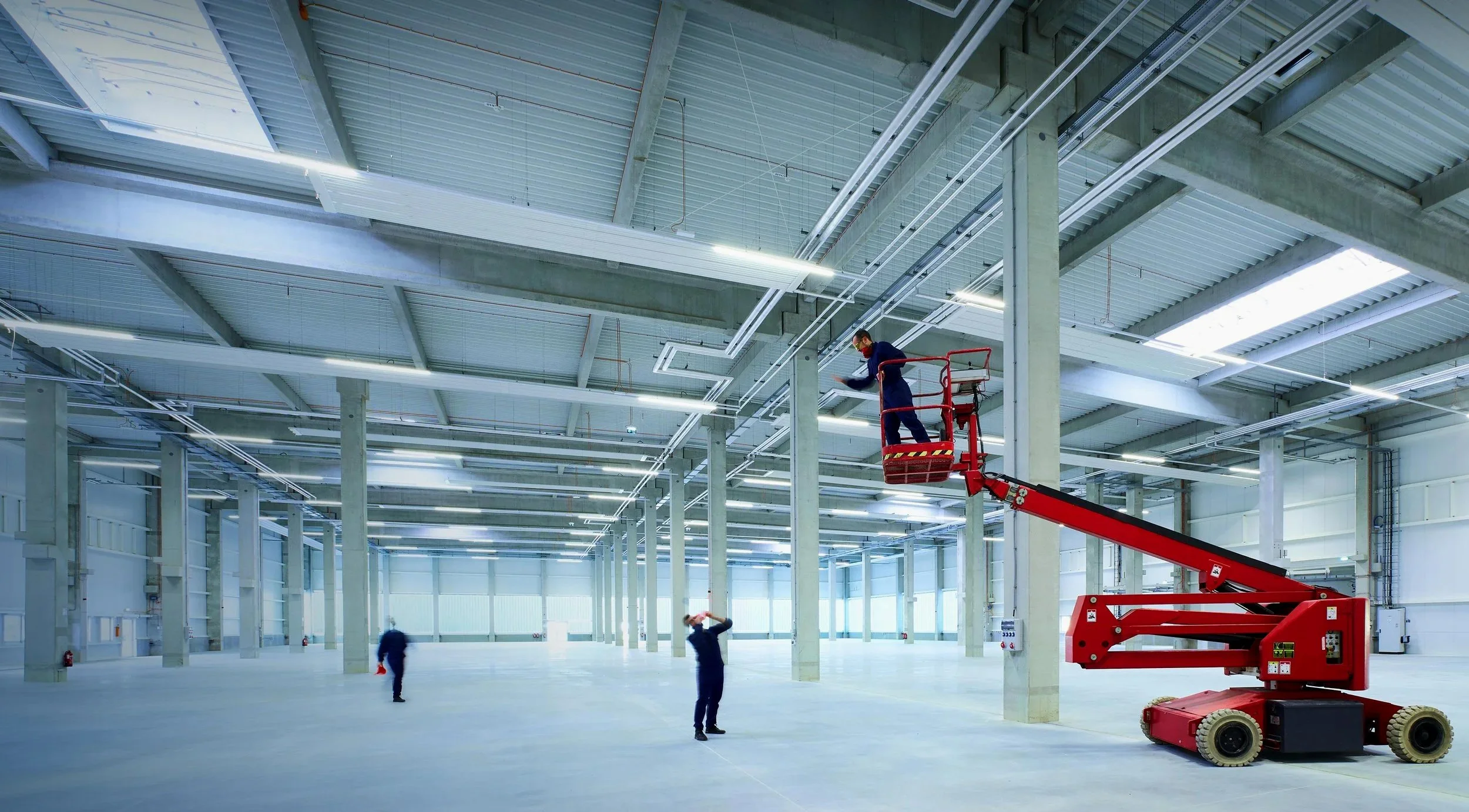 Logistikhalle mit hoher Decke und Hebebühne – Erfahrung im Hochbau trifft auf emotionale Architektur