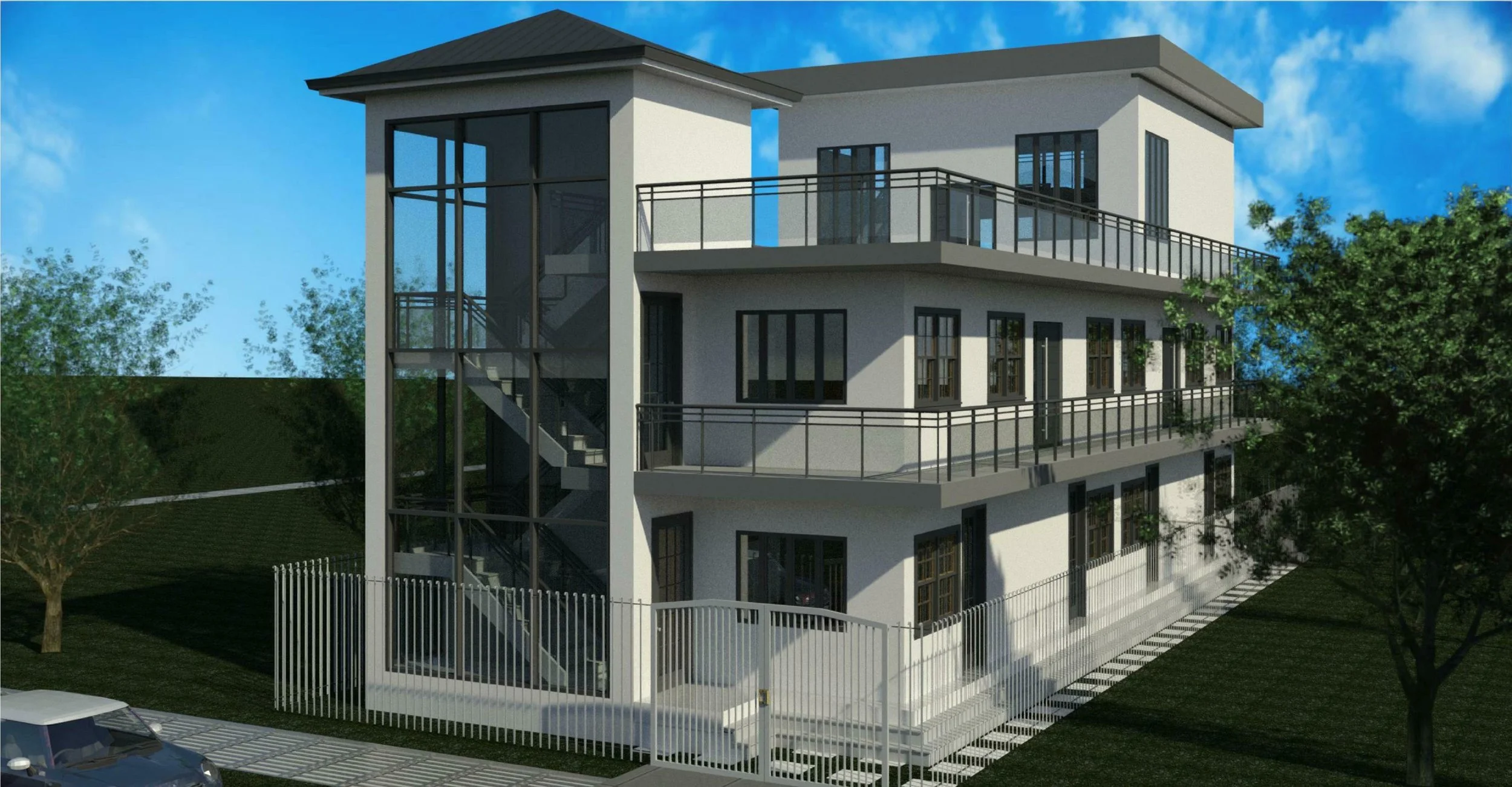 A modern, multi-story residential building with white exterior walls, black window frames, and multiple balconies with black railings. There is an outdoor staircase enclosed in glass on one side, a white fence around the perimeter, and trees with gre