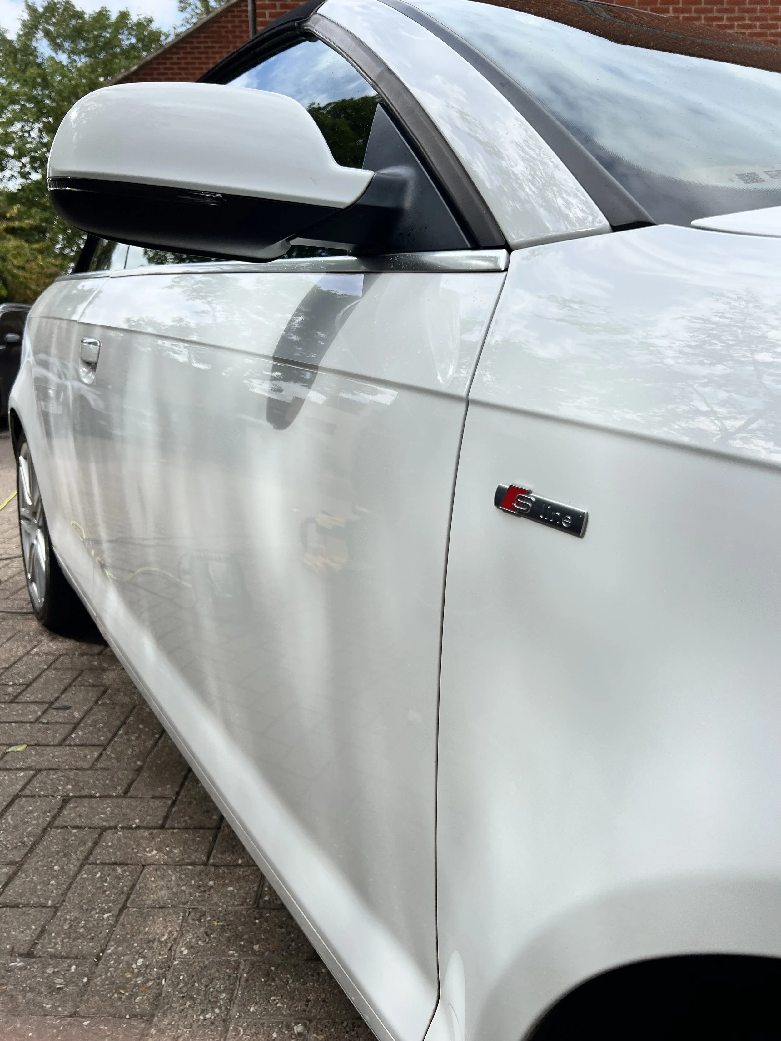 Close-up view of the front side of a white Audi S line car after a full detail valet by Oxford Car Detailing.