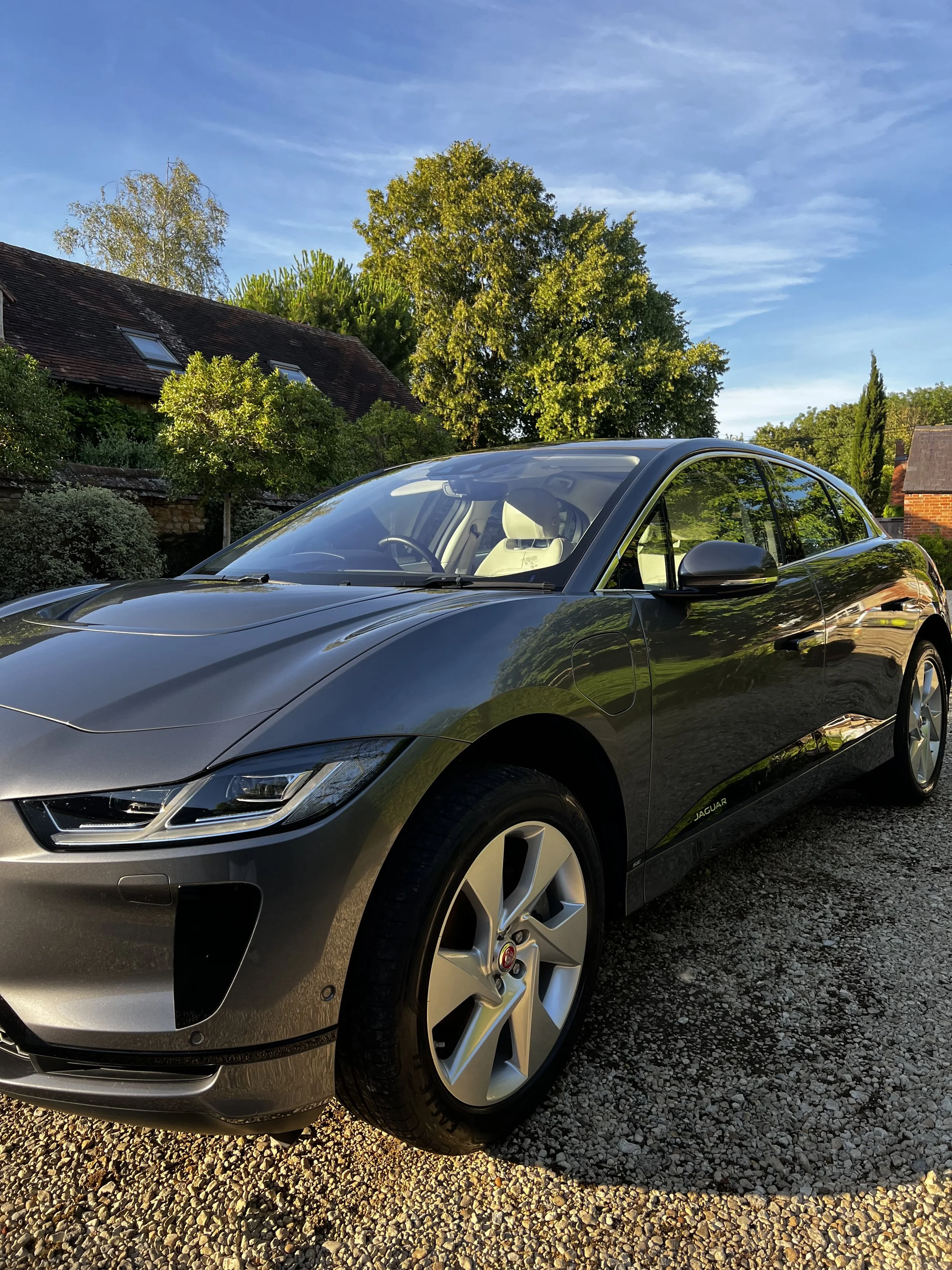 Gray Jaguar electric car parked on gravel driveway after full valet.