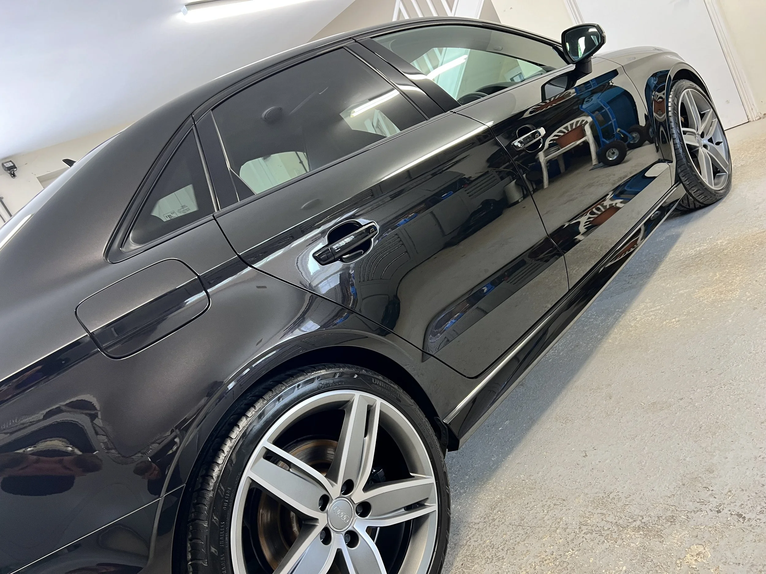 Black Audi sports car inside a garage after full valet and detail and ceramic coating.