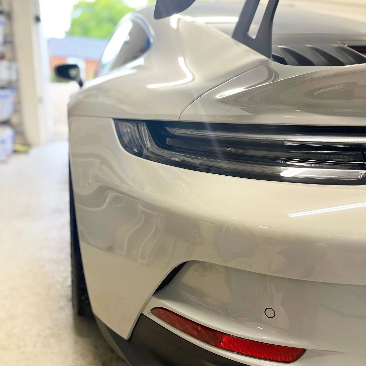 Close-up of the front right corner of a silver luxury car after a full detail valet by Oxford Car Detailing.