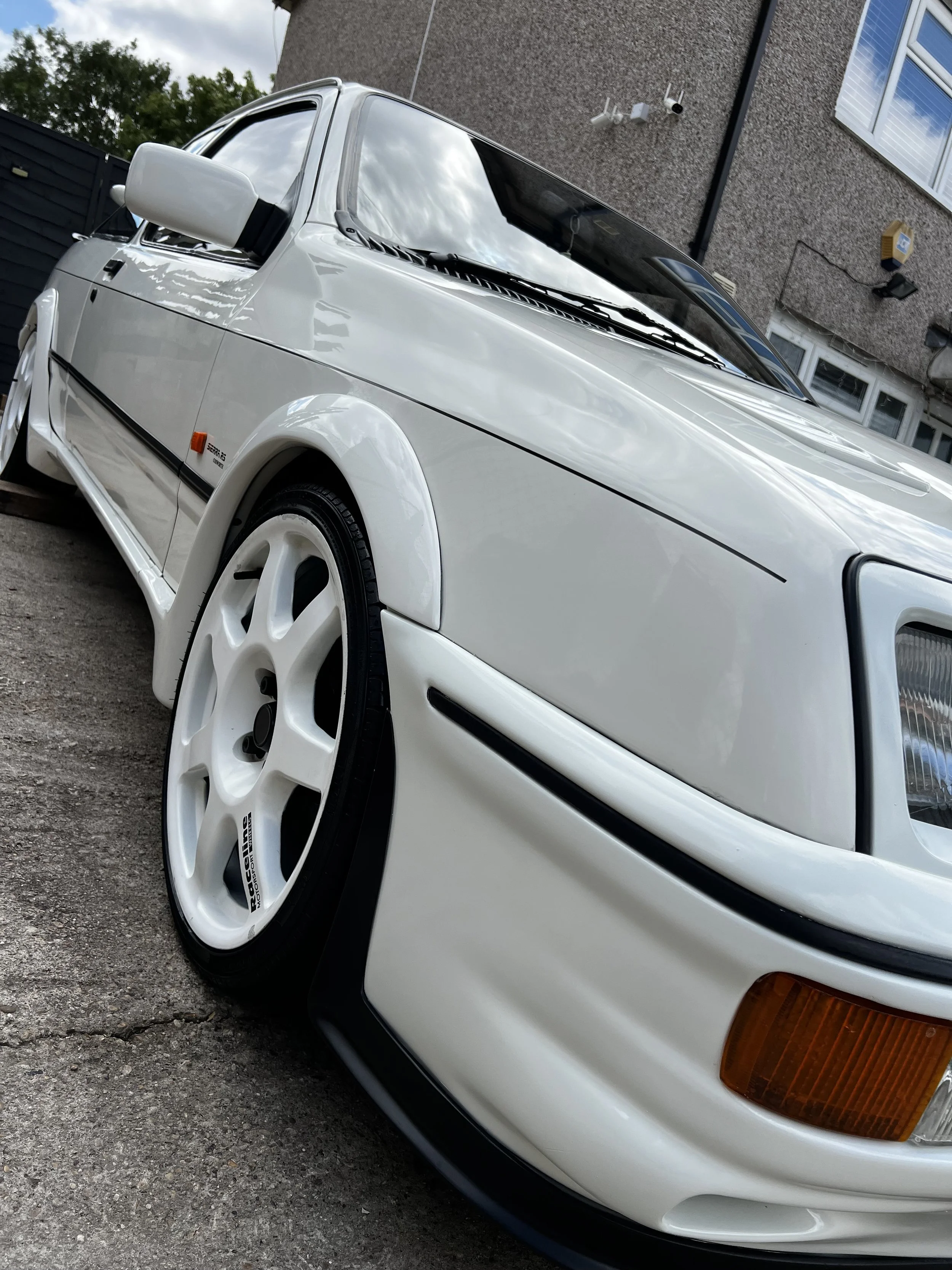 Close-up of a white vintage car with custom white wheels after OCD car valet and detailing package.