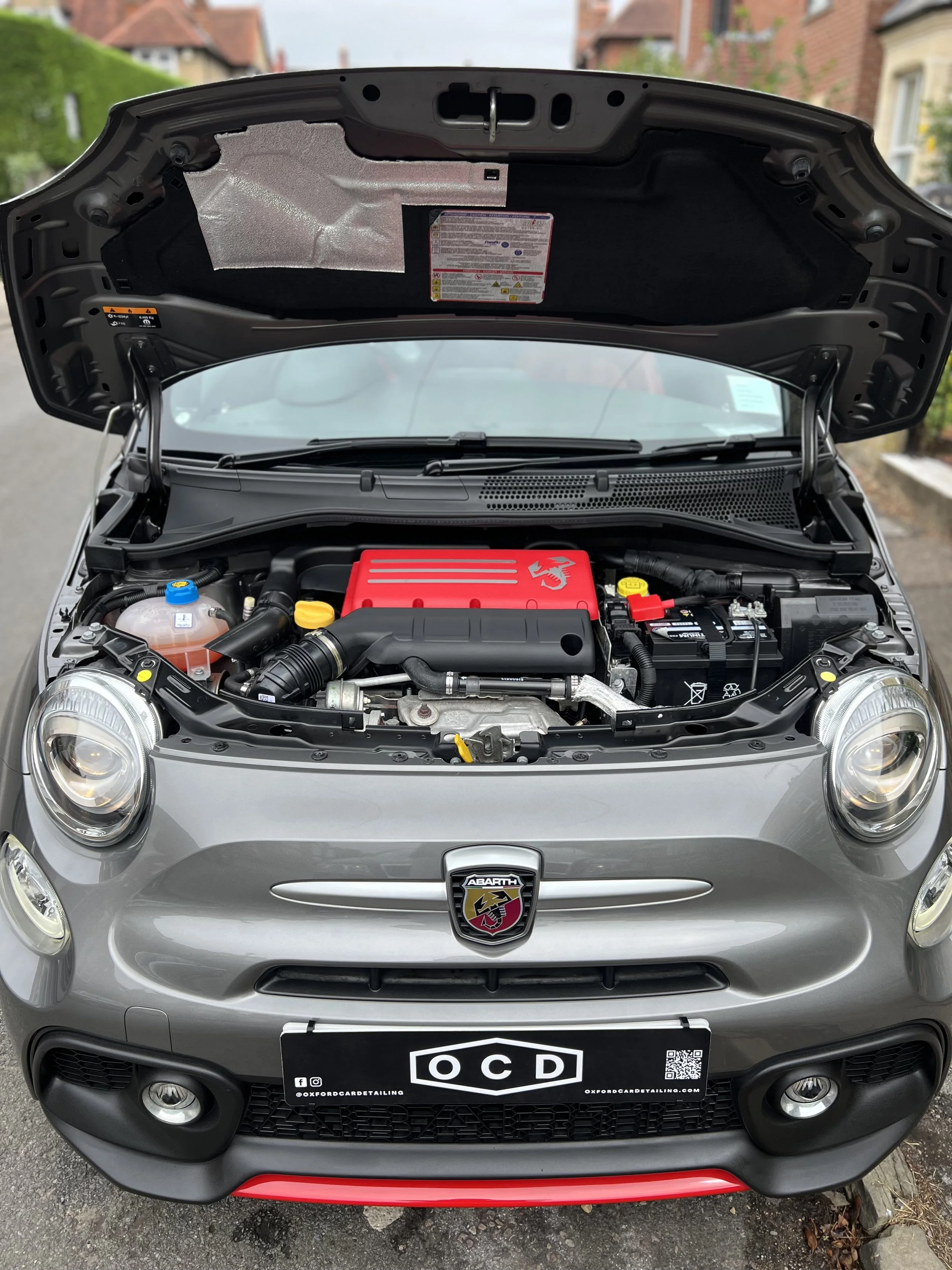 Front view of a silver Abarth car with its hood open, showing the engine bay and engine components after OCD mobile car valet and detailing package.