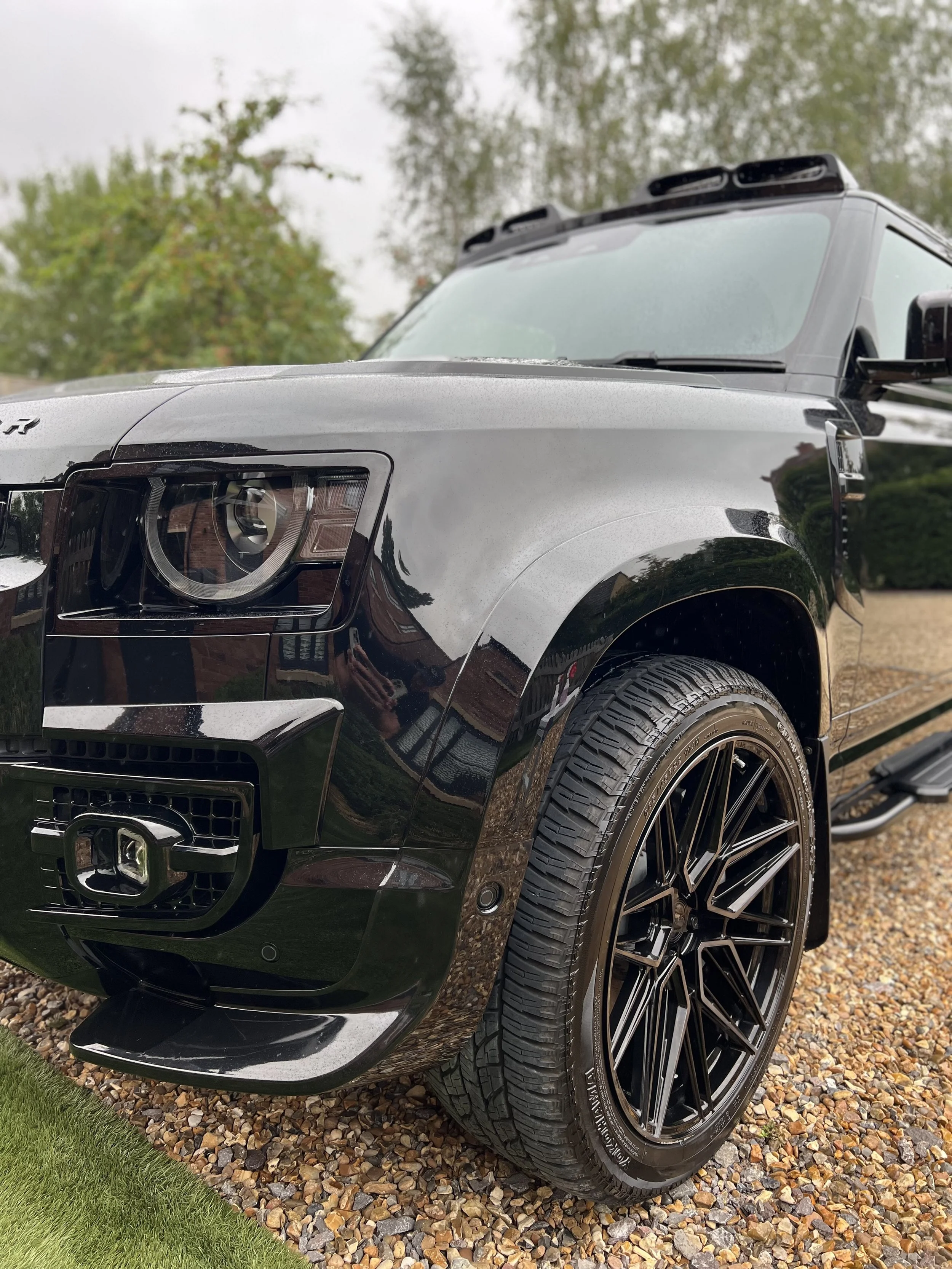 Close-up of a black luxury SUV showing the front left side after OCD car valet and detailing package.