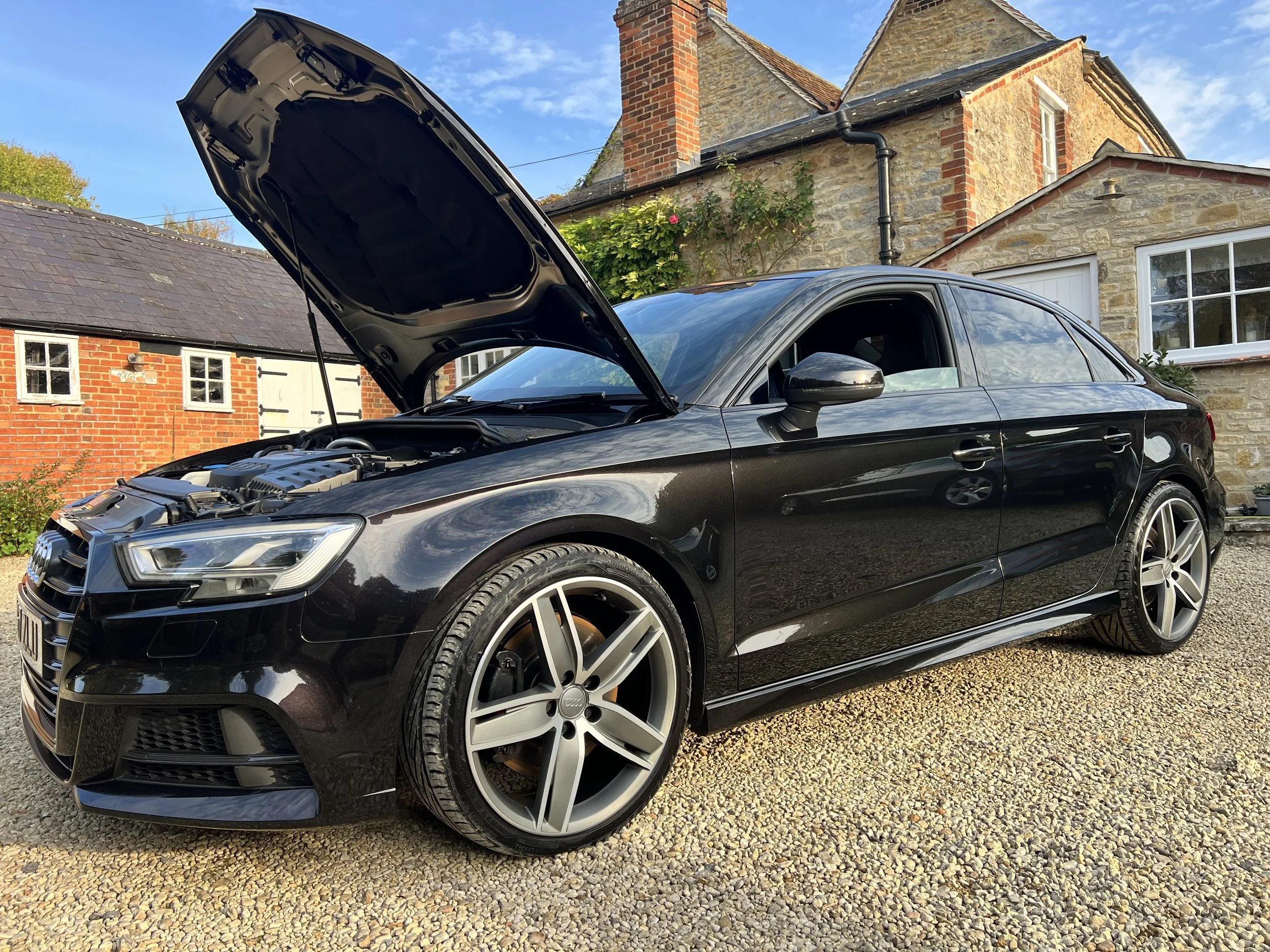 Black Audi car with open hood after full valet and detail and ceramic coating.