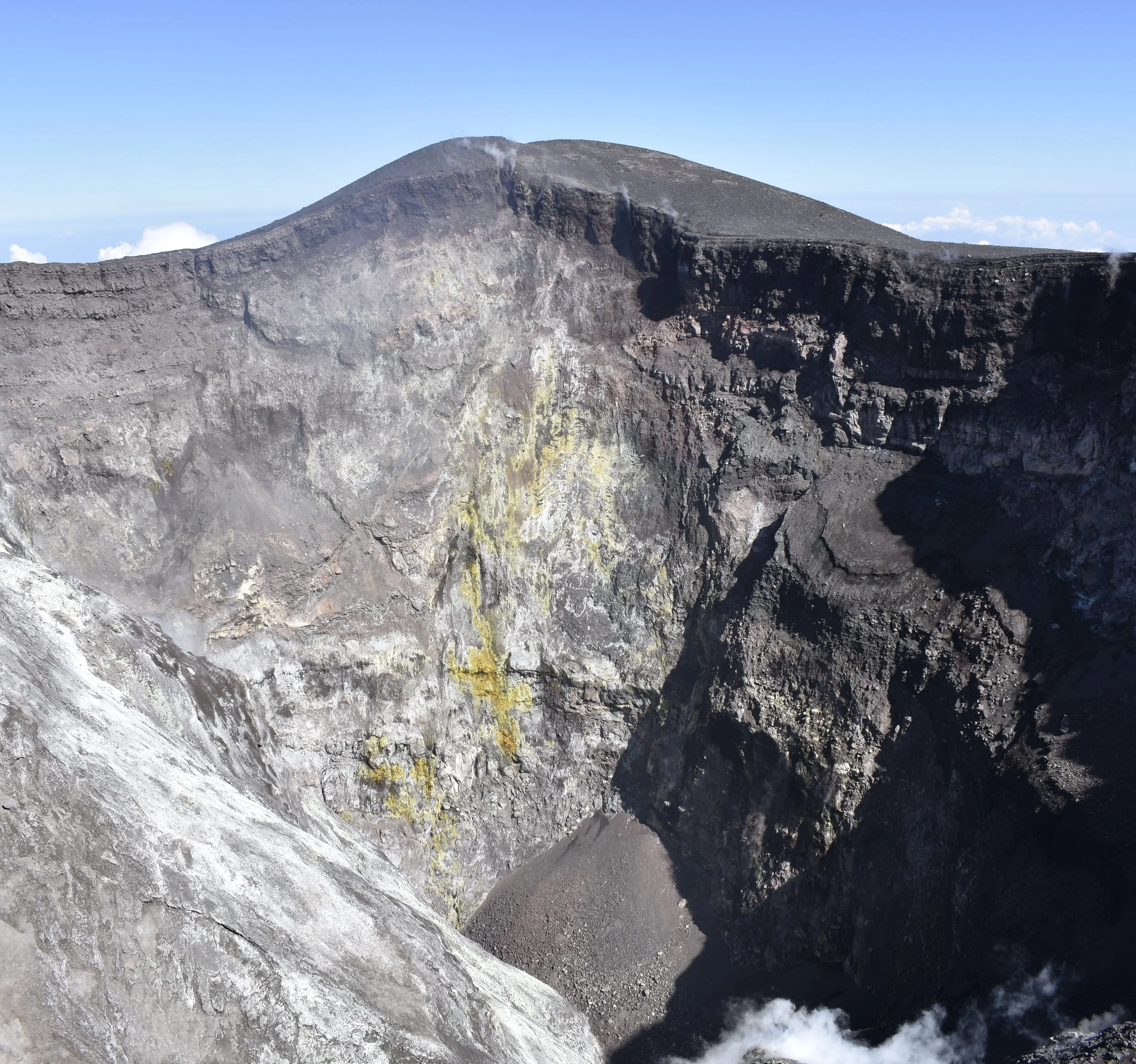 Un vulcano attivo con fumarole e superficie di roccia vulcanica.