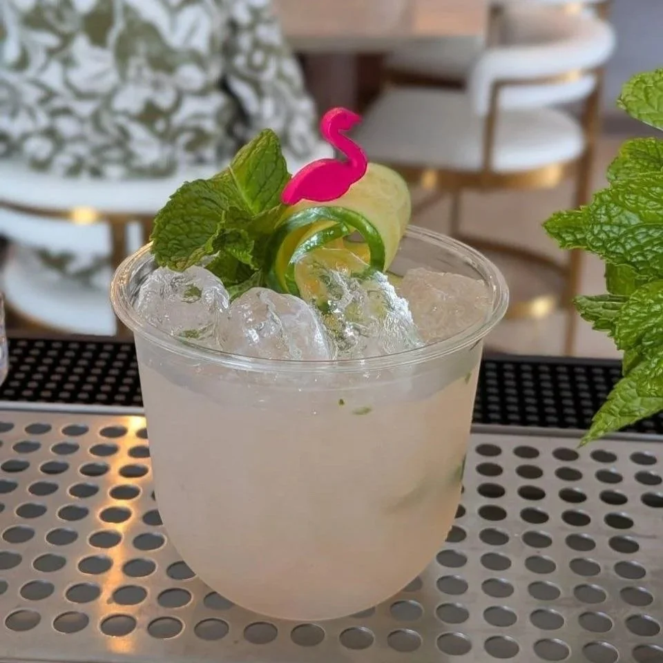 Social Butterfly ATX Island Wood Smash cocktail served over crushed ice, garnished with fresh mint, a cucumber ribbon, and a pink flamingo pick at an Austin mobile bar event