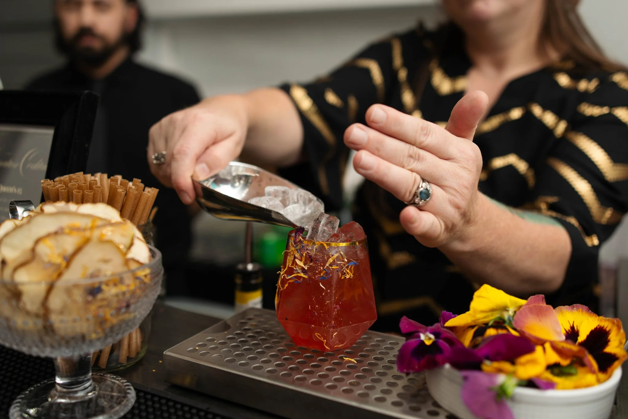 A mobile bartender in Austin, pours a colorful custom cocktail at a private event.
