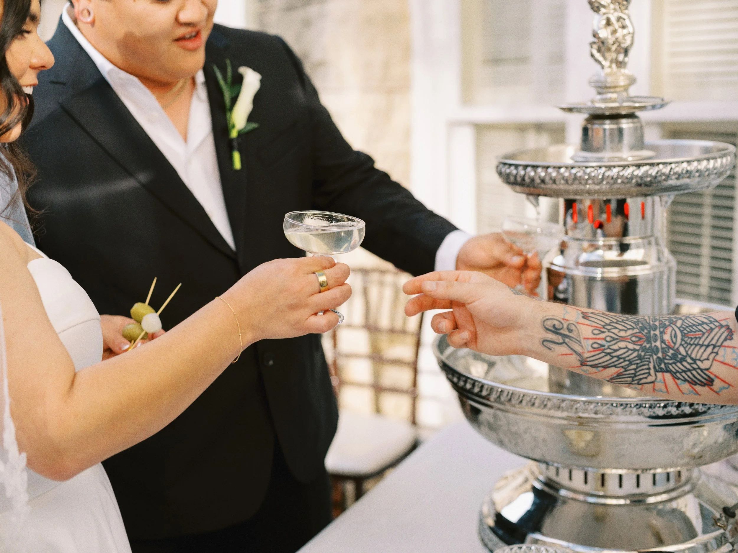 People pouring champagne into glasses at a celebration or wedding event.