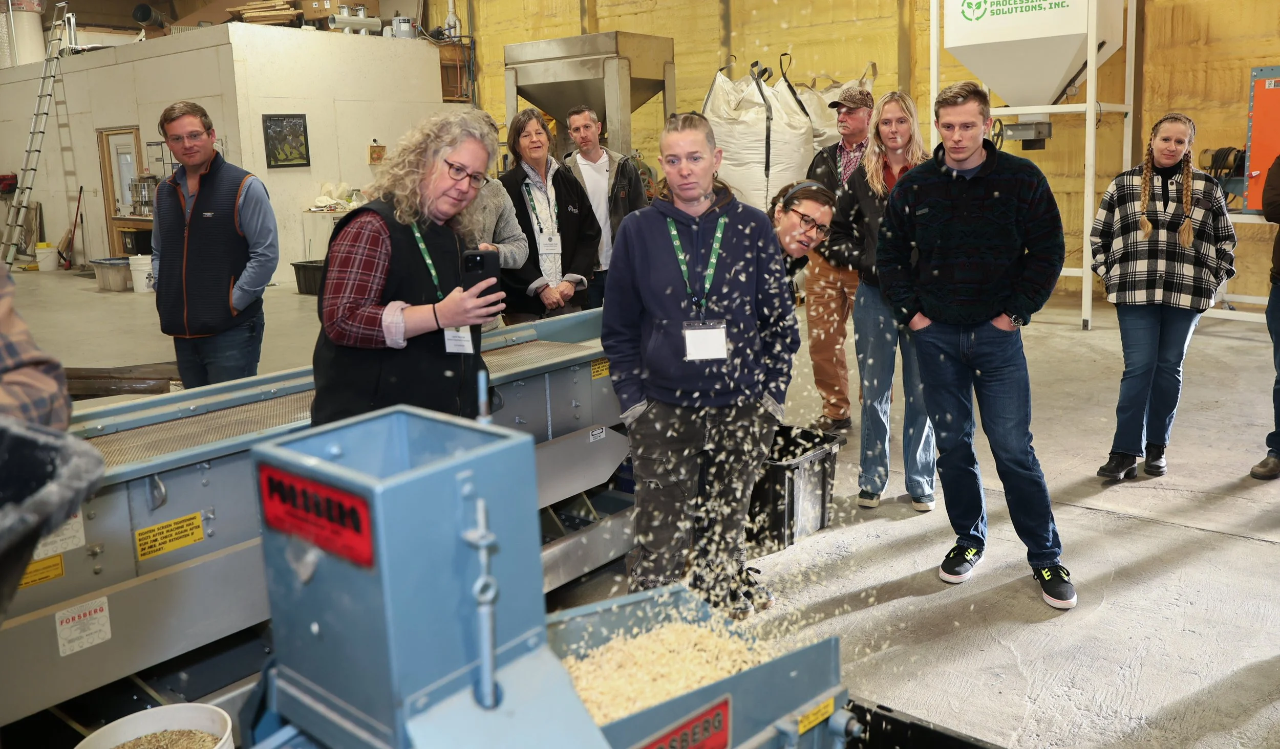 Tour participants watching and learning as grain is processed