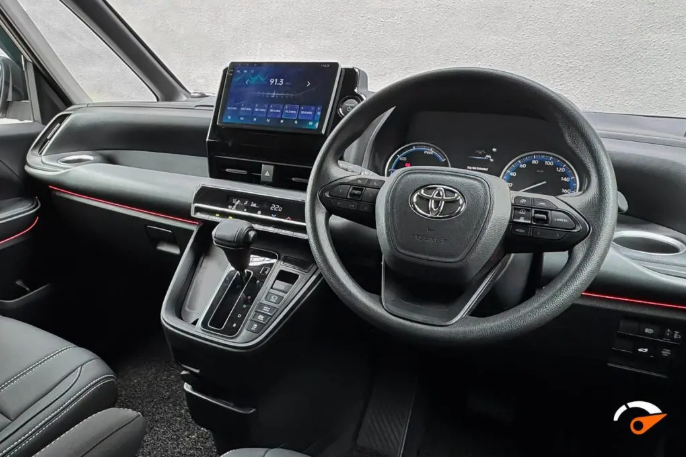 Interior of a Toyota vehicle showing the dashboard, steering wheel, and center console with a touchscreen display.