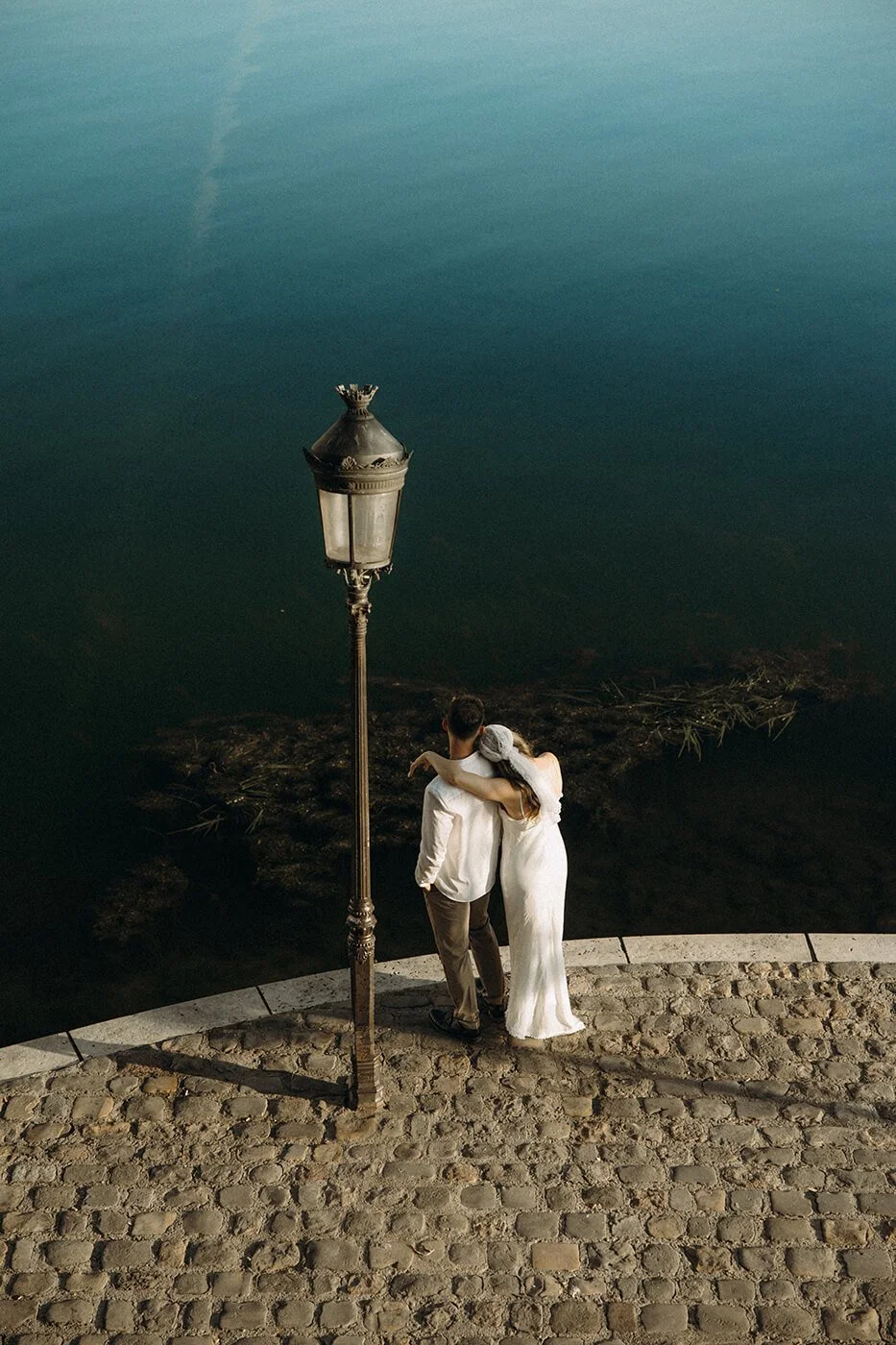 Golden hour Paris elopement on St Louis Ile, intimate couple portrait overlooking the Seine River in warm cinematic light.