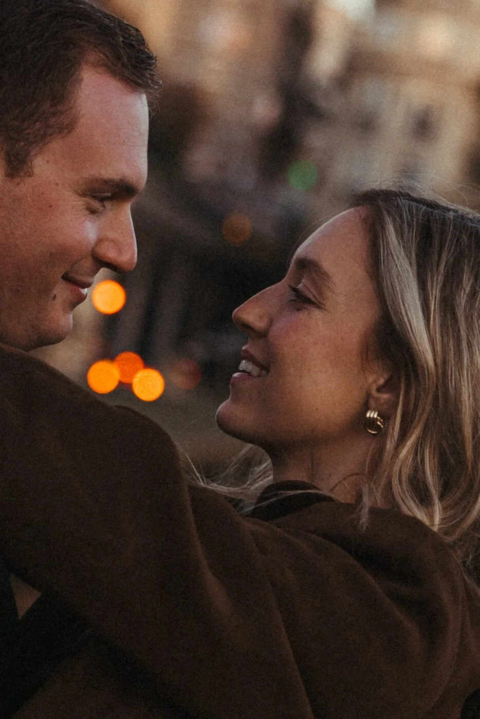 Moody cinematic portrait of a couple in Paris captured in warm evening light.