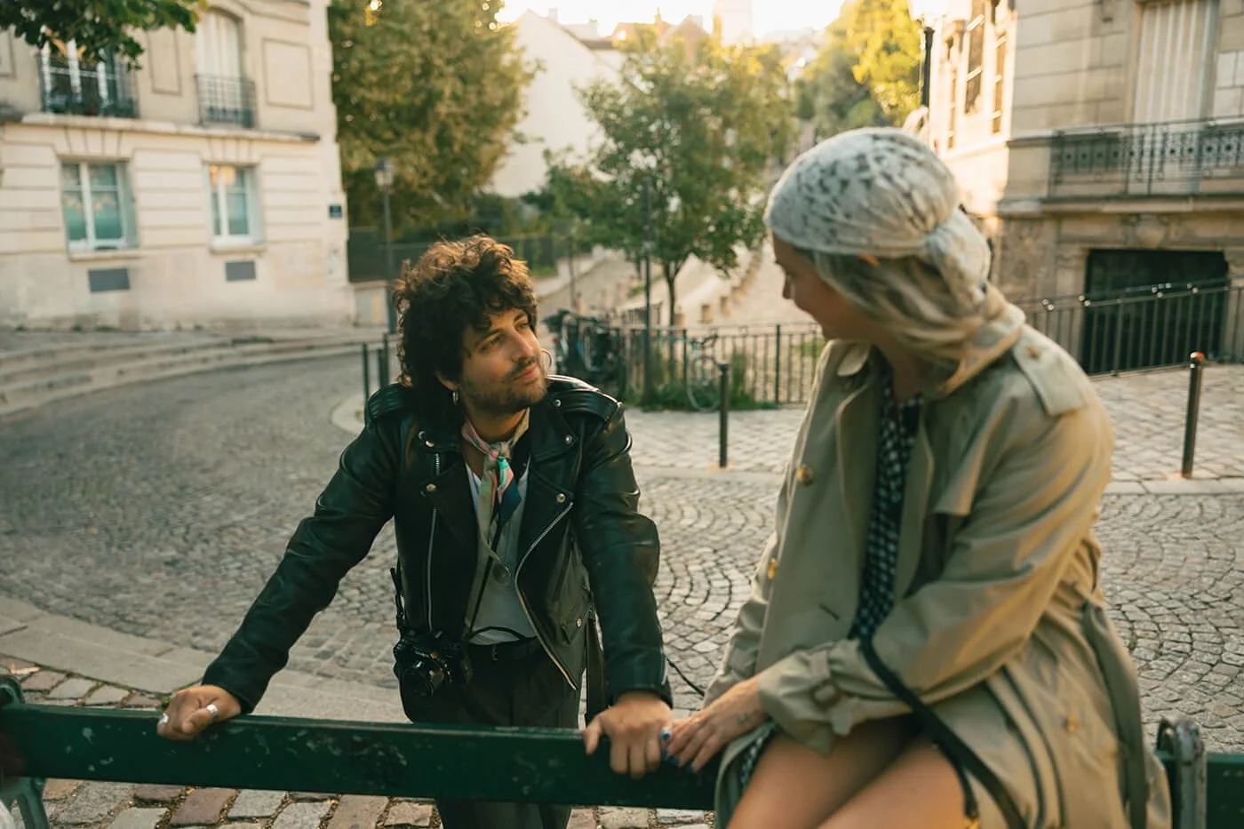 Couple on the bench while taking pictures for lovely engagement session in a candid way in Paris.