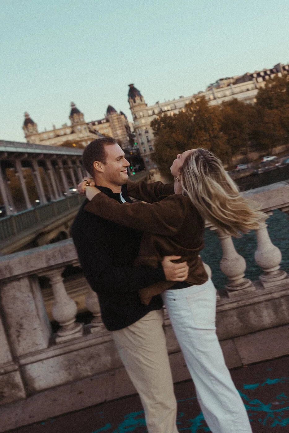 Cinematic couple session on Bir-Hakeim Bridge in Paris with the Eiffel Tower in the background.