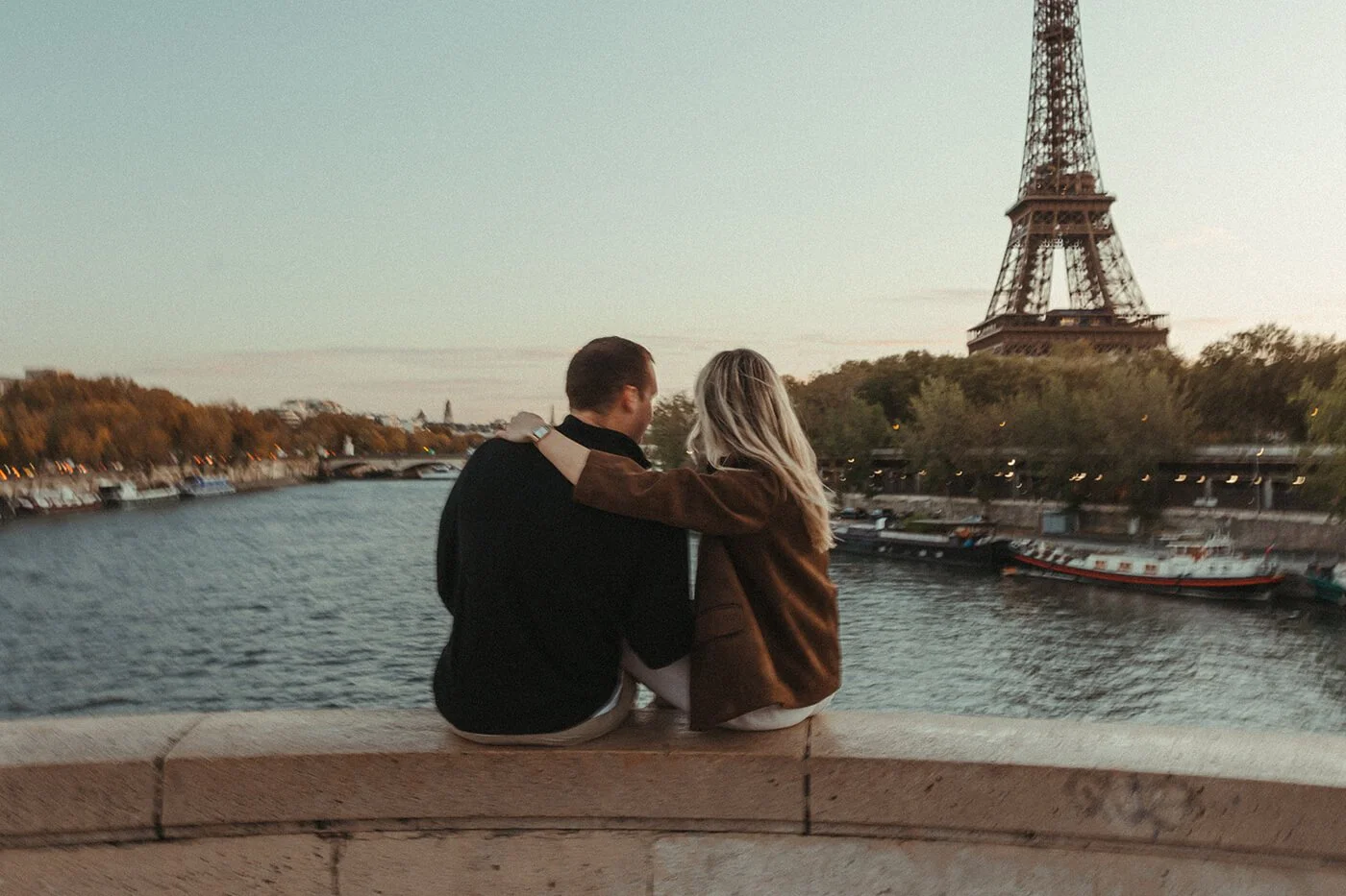 Romantic couple embracing in golden light during a cinematic Paris street photoshoot.
