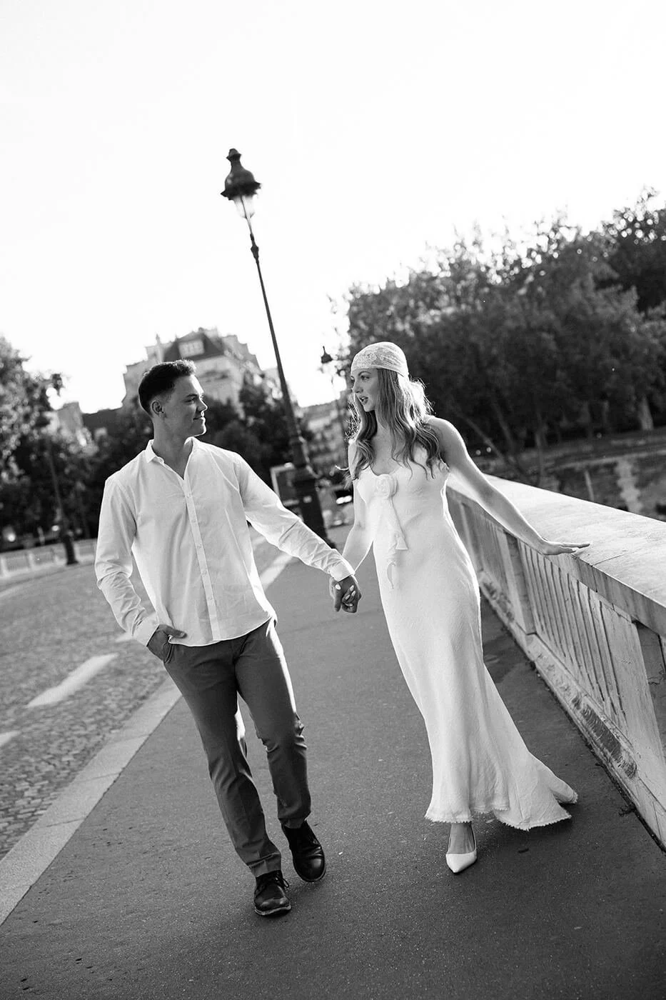 Romantic couple during their Paris elopement standing on a bridge at sunset, cinematic golden hour portrait captured by a Paris elopement photographer.