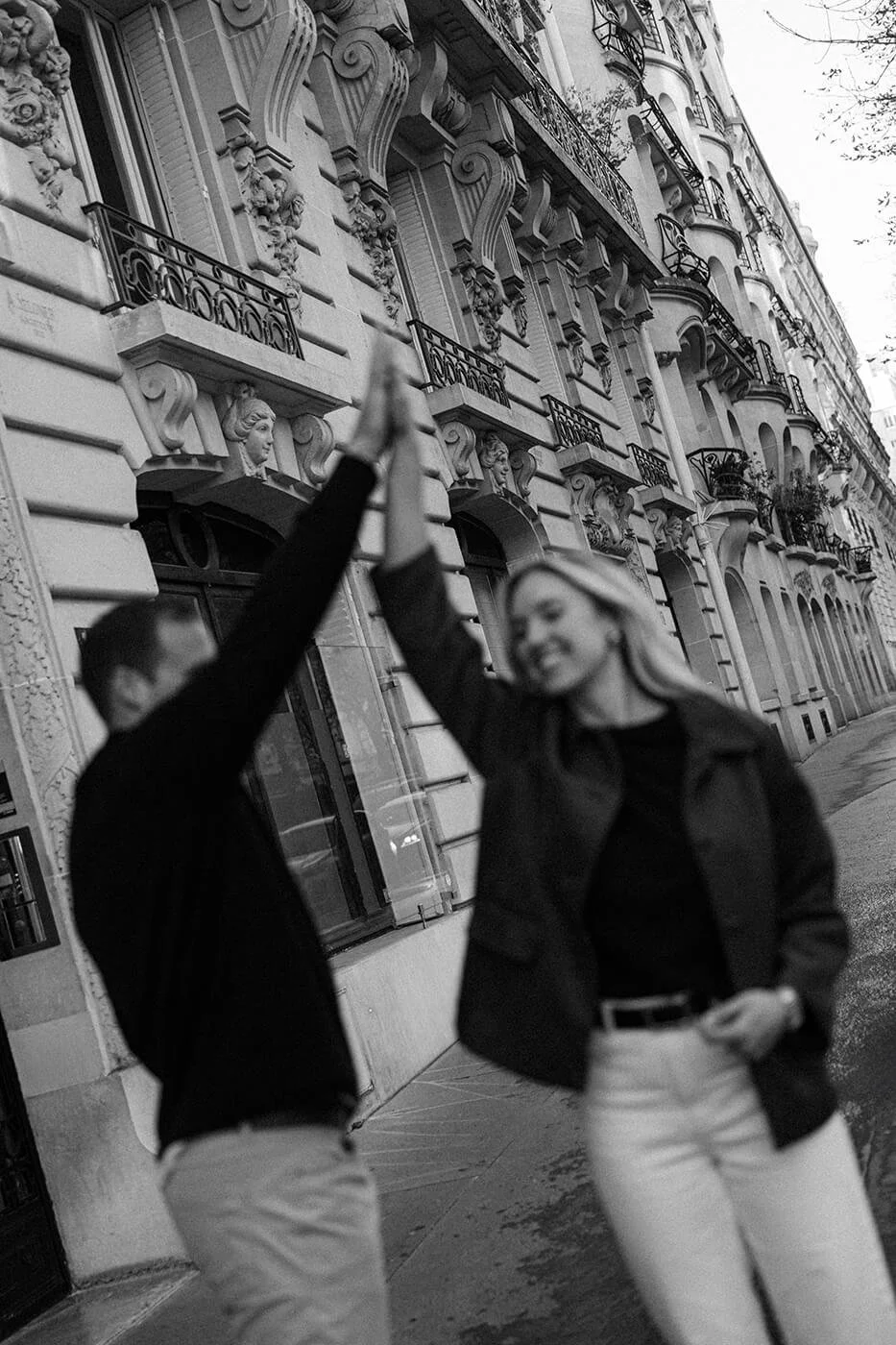 Elegant couple session in Paris under classic stone arches in a cinematic style.