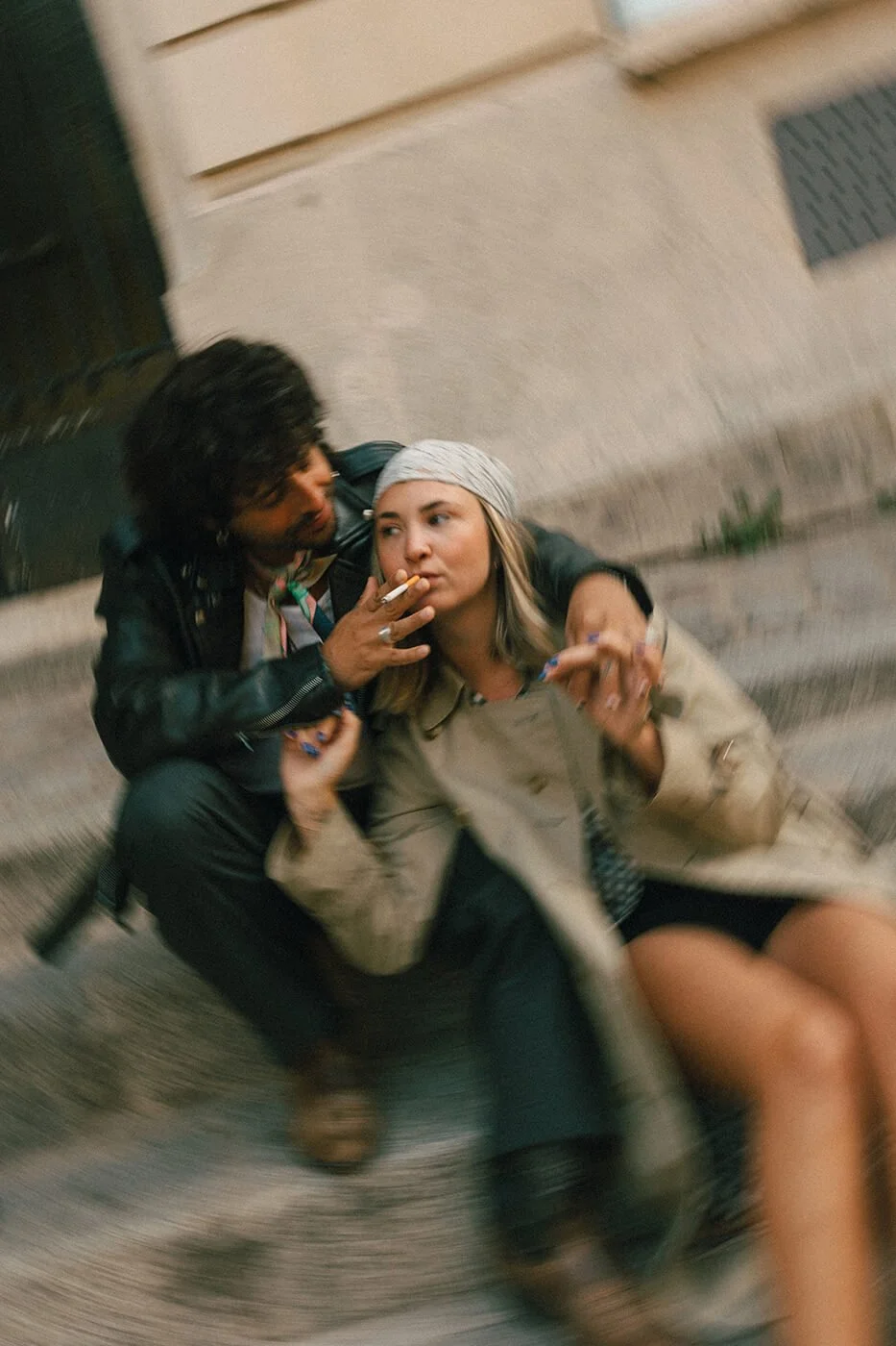 Playful couple sitting on steps in Montmartre during their Paris engagement session, relaxed and authentic love story photography.