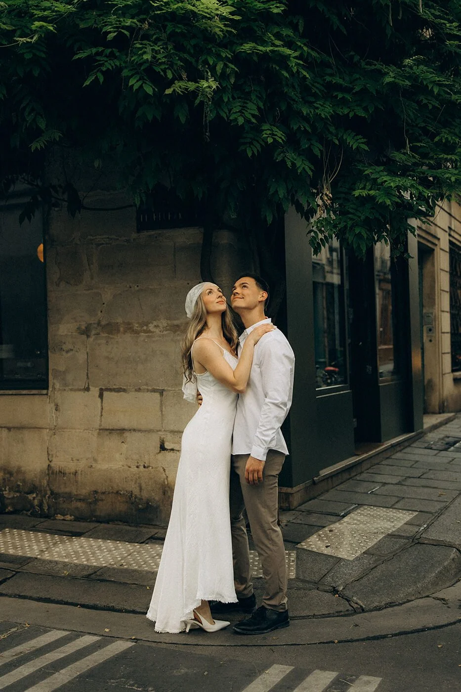 Playful couple sitting on steps in Il Saint Louis during their Paris engagement session, relaxed and authentic love story photography.