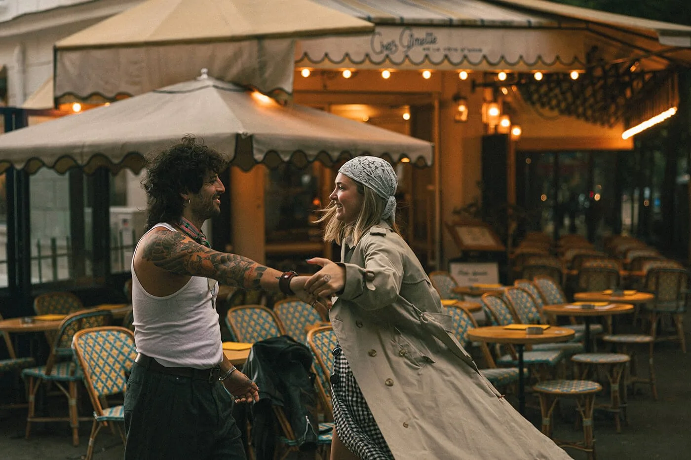 Playful couple moment at a Paris café during their engagement session, cinematic and romantic Montmartre photography.