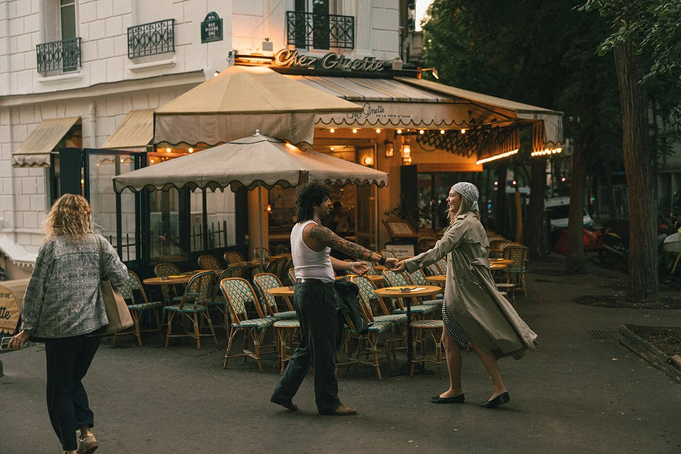 Playful couple moment at a Paris café during their engagement session, cinematic and romantic Montmartre photography.