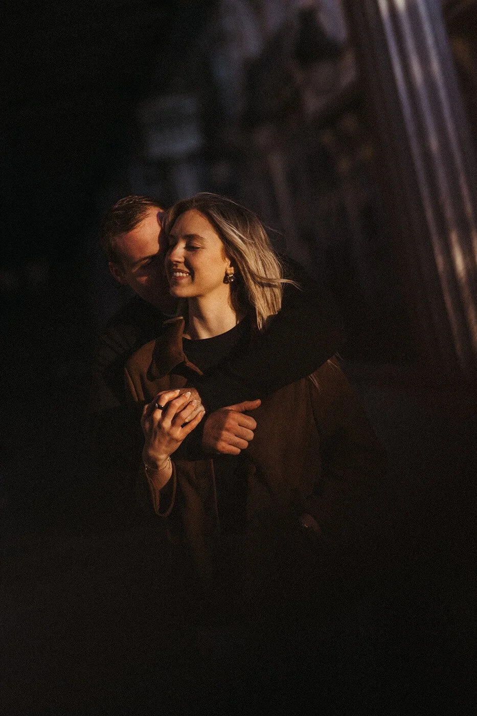 Couple photographed at sunrise in Paris with the Eiffel Tower in soft morning light.