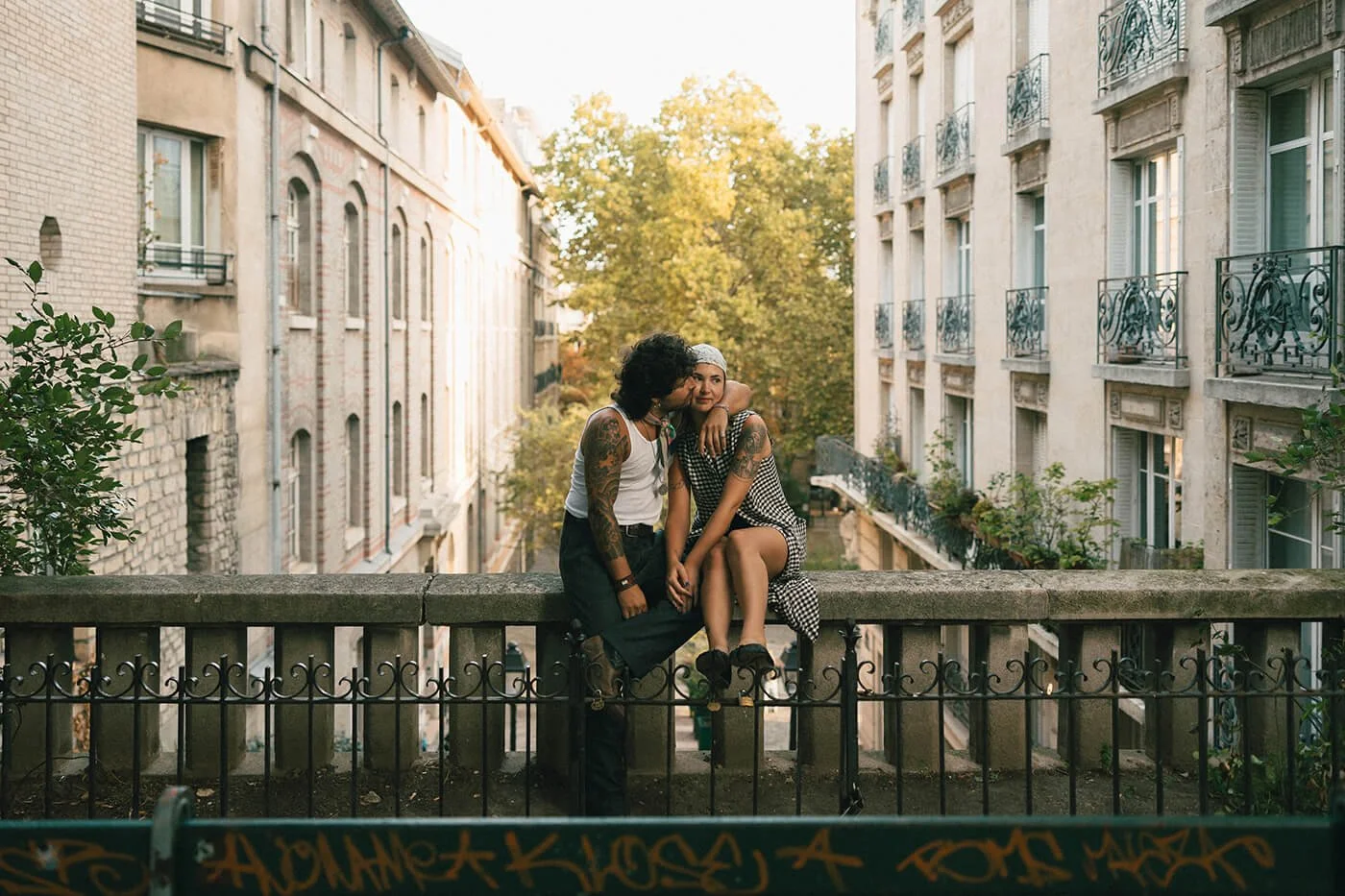 Candid kissing moment during engagement photoshoot couple on the balcony.