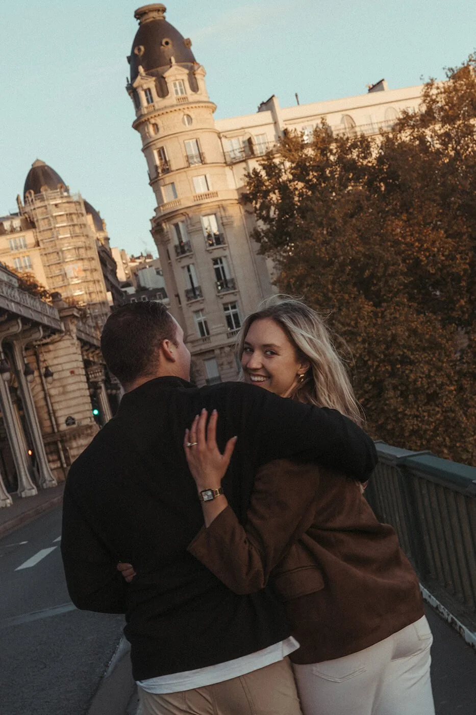 Romantic couple portrait in Paris with elegant architecture and soft natural light.