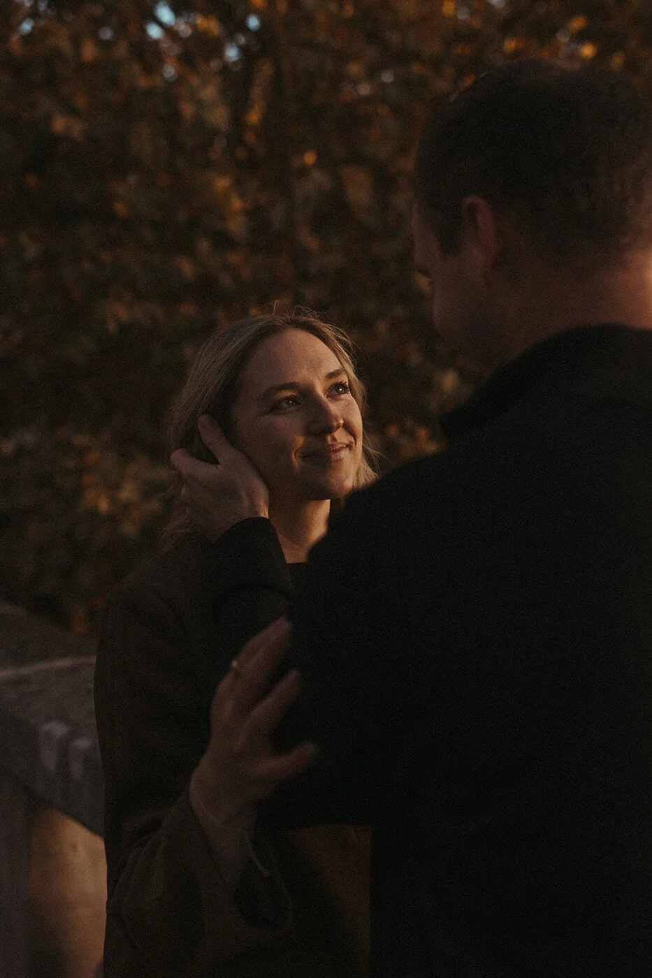 Romantic couple session in Paris with the Eiffel Tower visible from a scenic bridge.