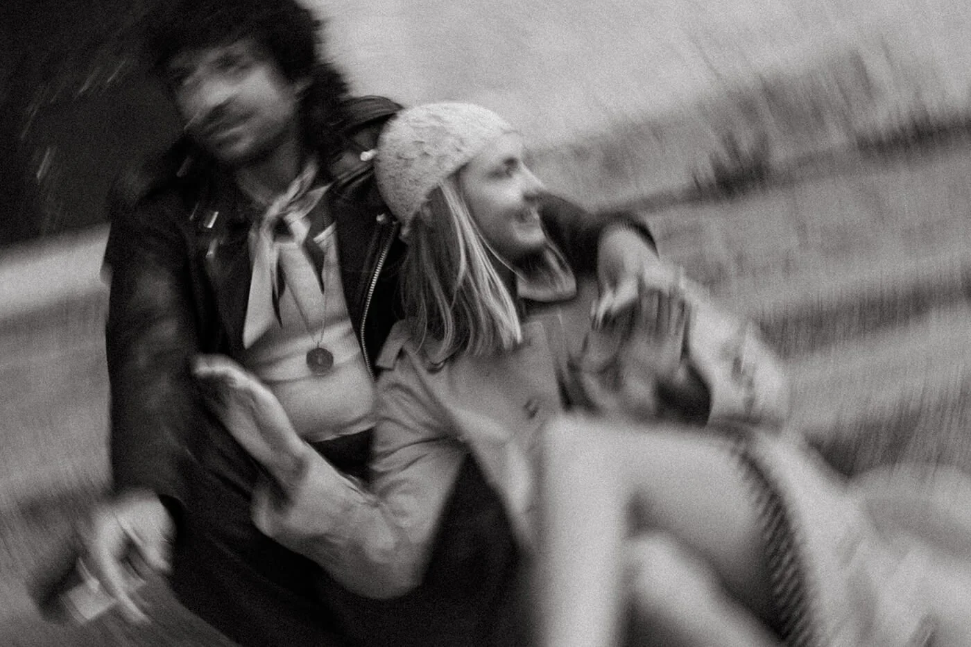 Black and white cinematic portrait of a couple in motion on a Paris street, timeless engagement photography in Montmartre.