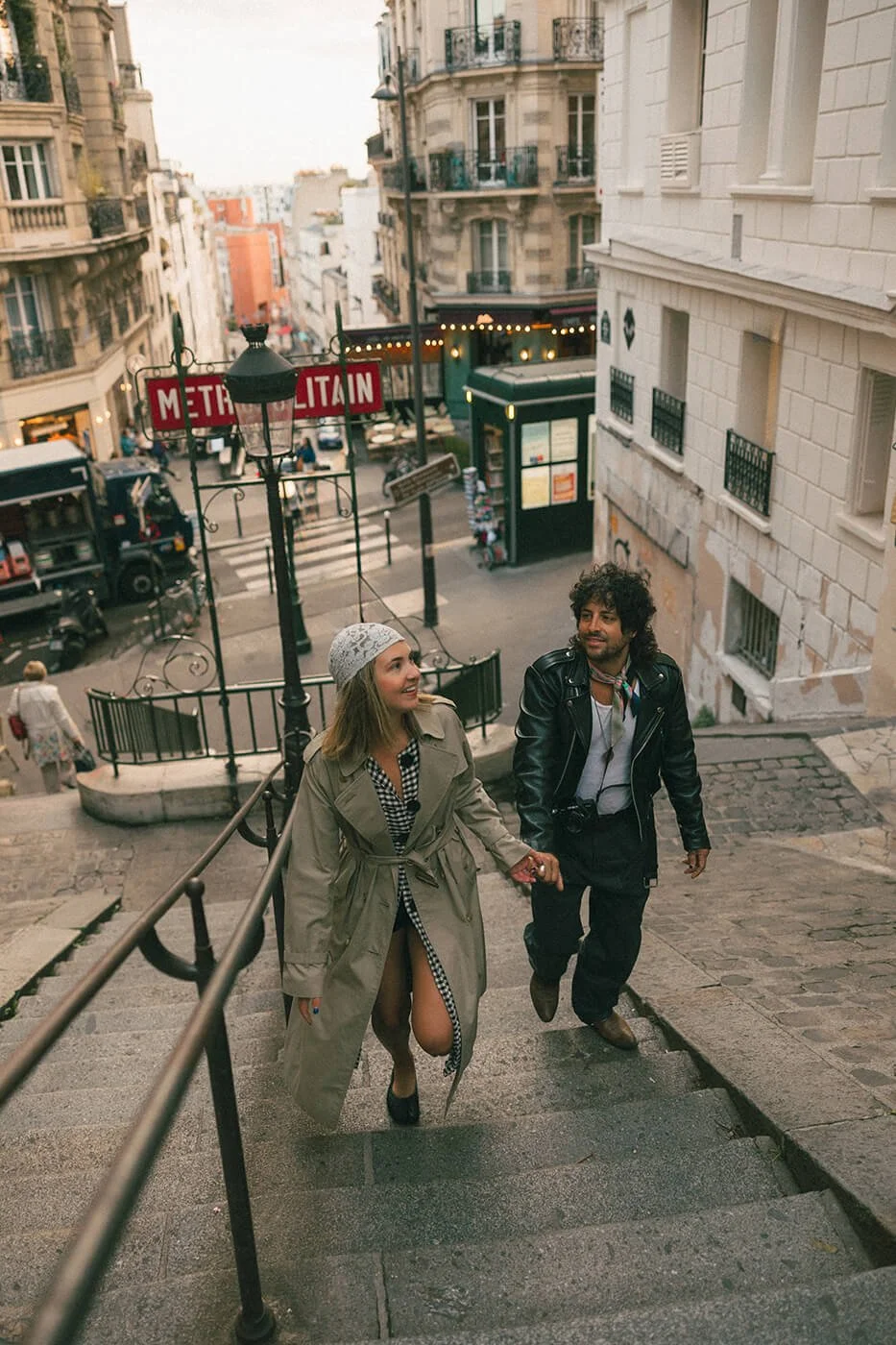 Romantic engagement session in Paris on historic stone steps, candid couple moment in Montmartre neighborhood.