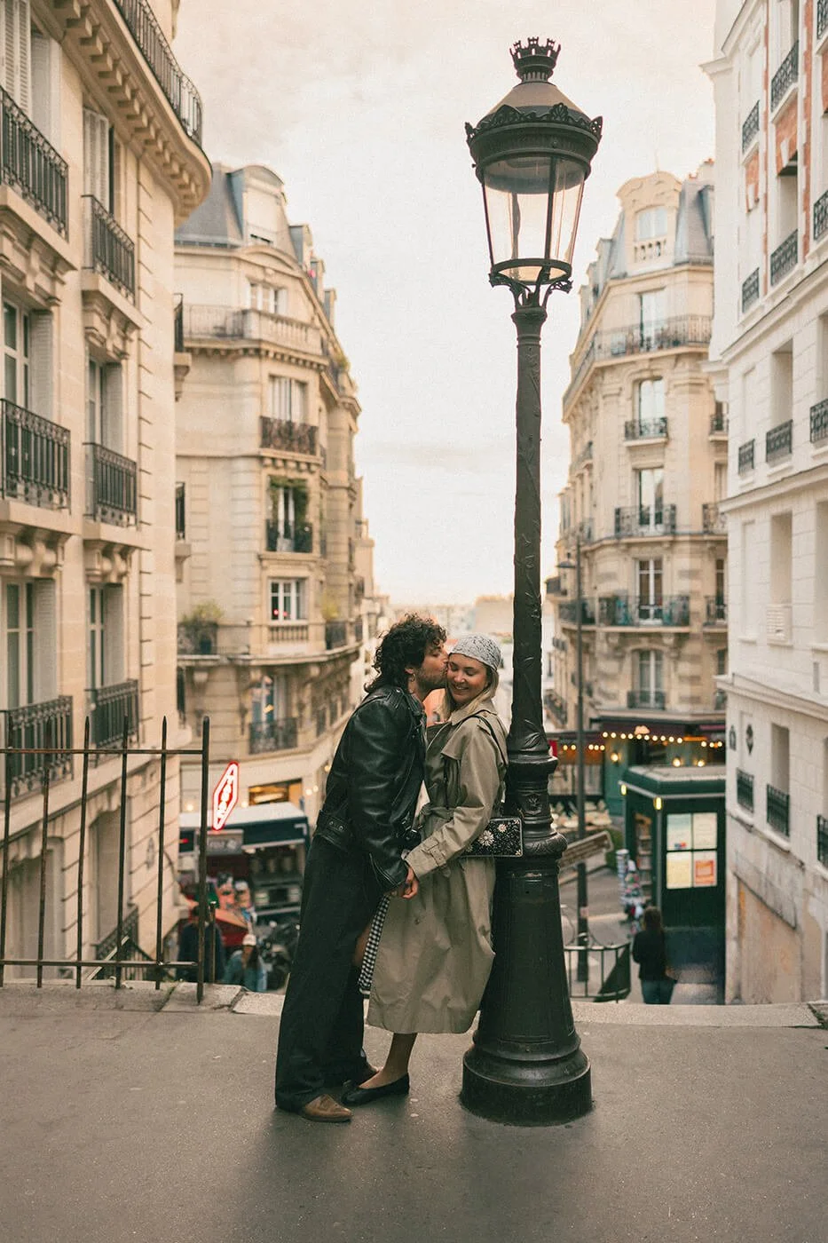 A couple kissing during an engagement photoshoot in Montmartre by the lantern.