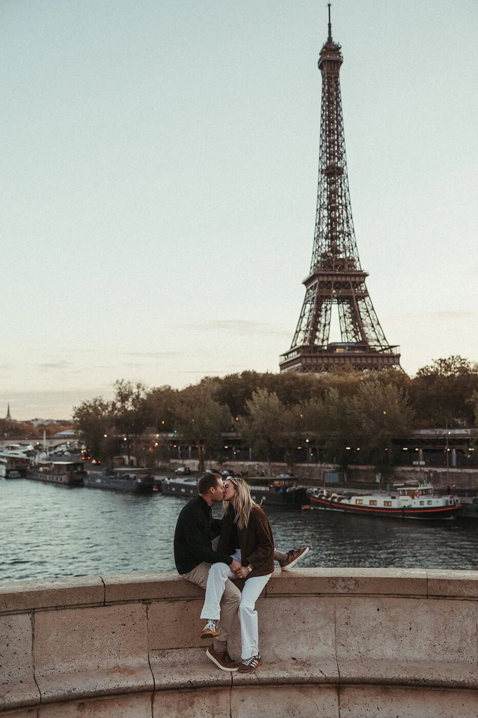 Cinematic couple photo in Paris with the Eiffel Tower in the background during a romantic sunrise session.