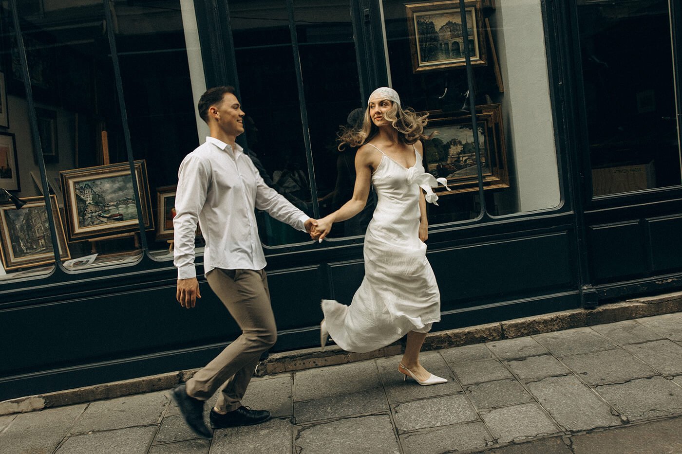 Candid couple running on the streets, lifestyle engagement photography in the heart of Paris.