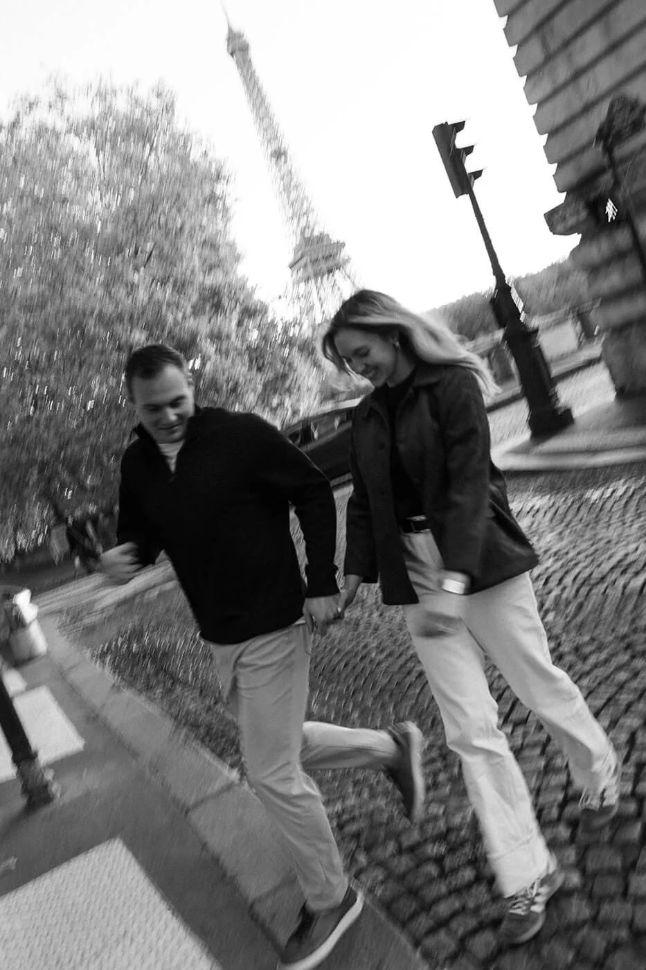 Black and white candid photo of a couple walking through the streets of Paris.