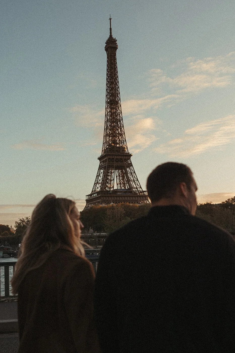 Elegant couple session in Paris under classic stone arches in a cinematic style.