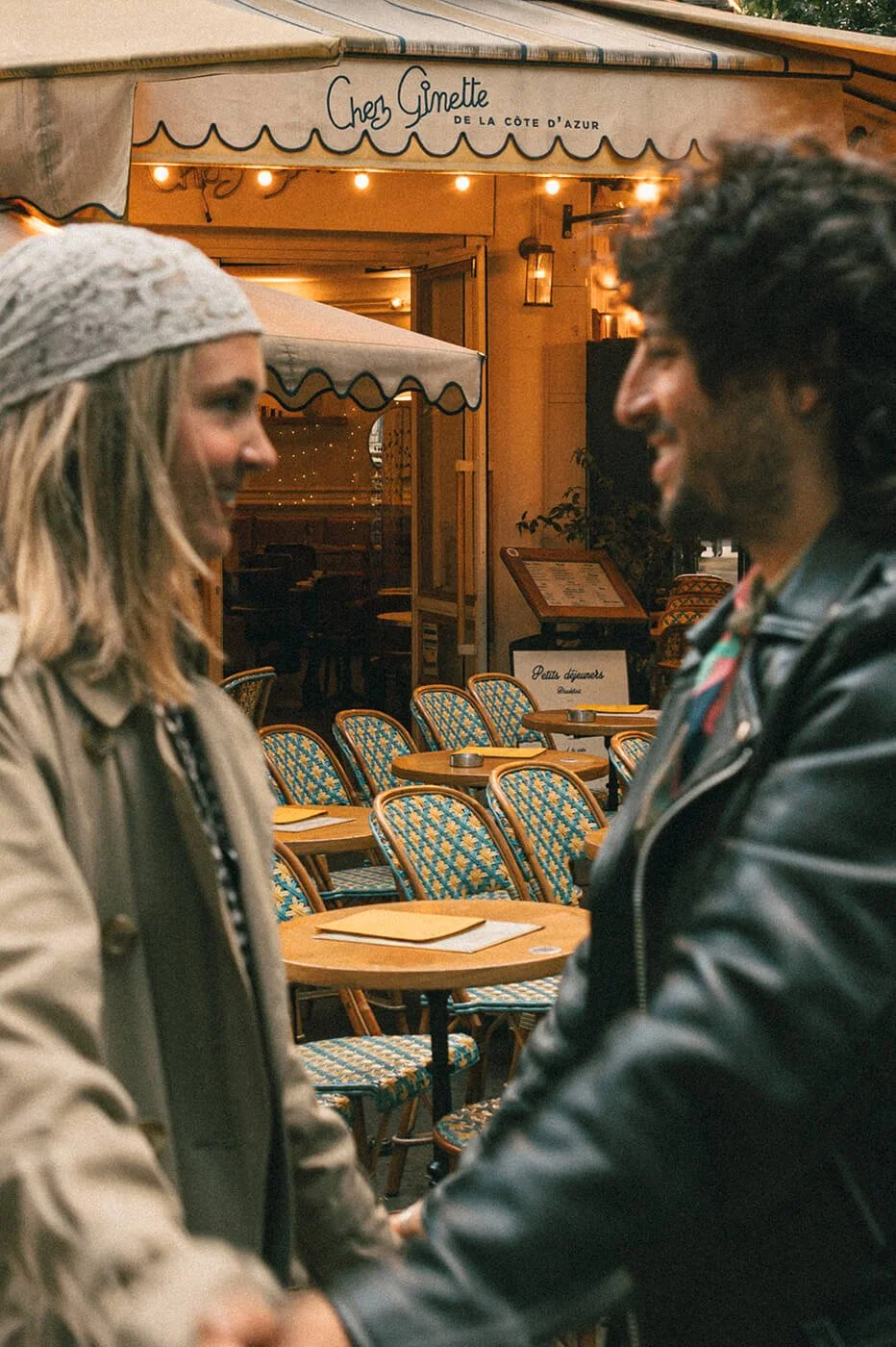 Close romantic portrait of a couple at a Paris café during their engagement session, soft light and authentic connection.