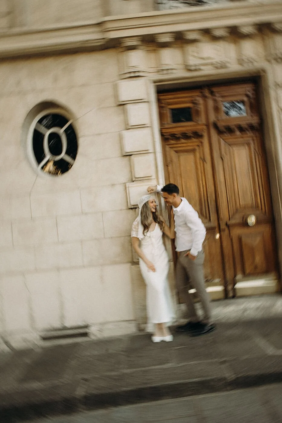 Romantic elopement session in Paris on historic stone street, candid couple moment in Montmartre neighborhood.