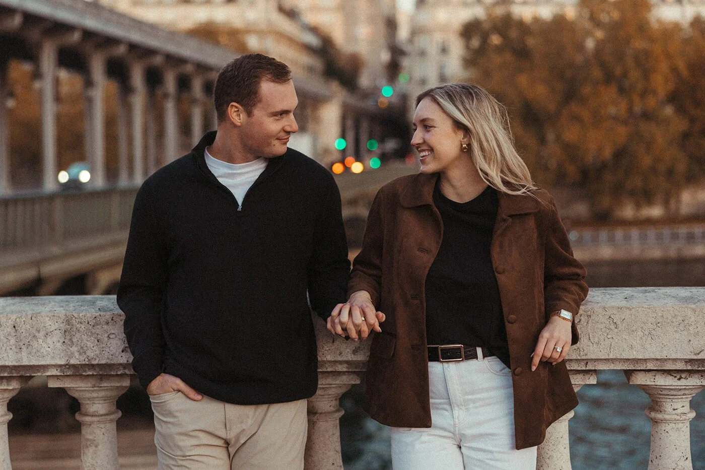 Romantic Paris couple session with the Eiffel Tower visible from a scenic riverside viewpoint.