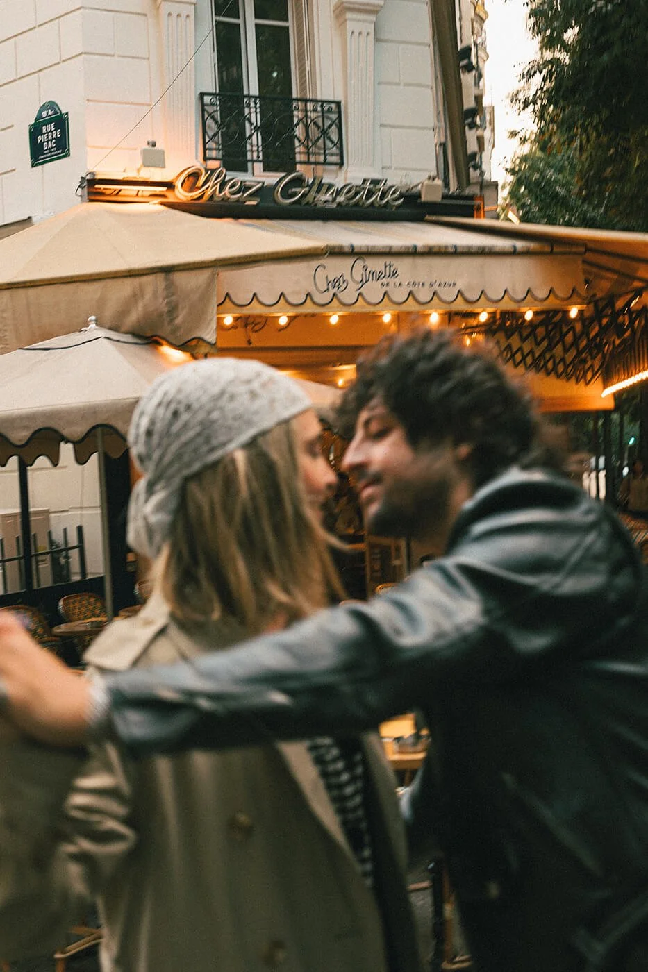 Playful couple moment at a Paris café during their engagement session, cinematic and romantic Montmartre photography.