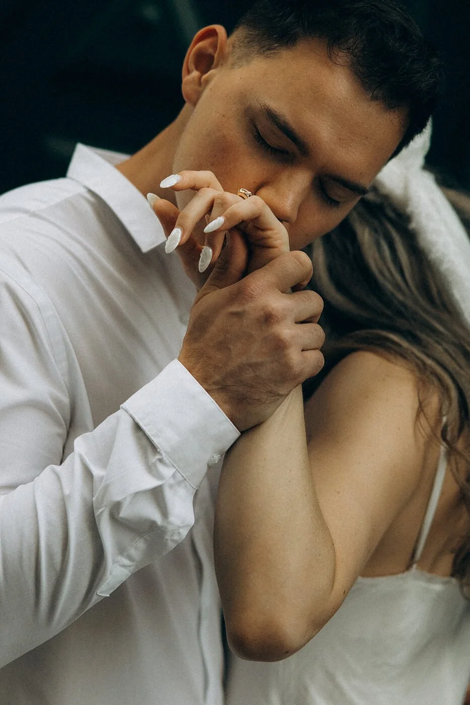 Romantic couple embracing under a Parisian lamppost during their engagement session in Paris, cinematic evening atmosphere.