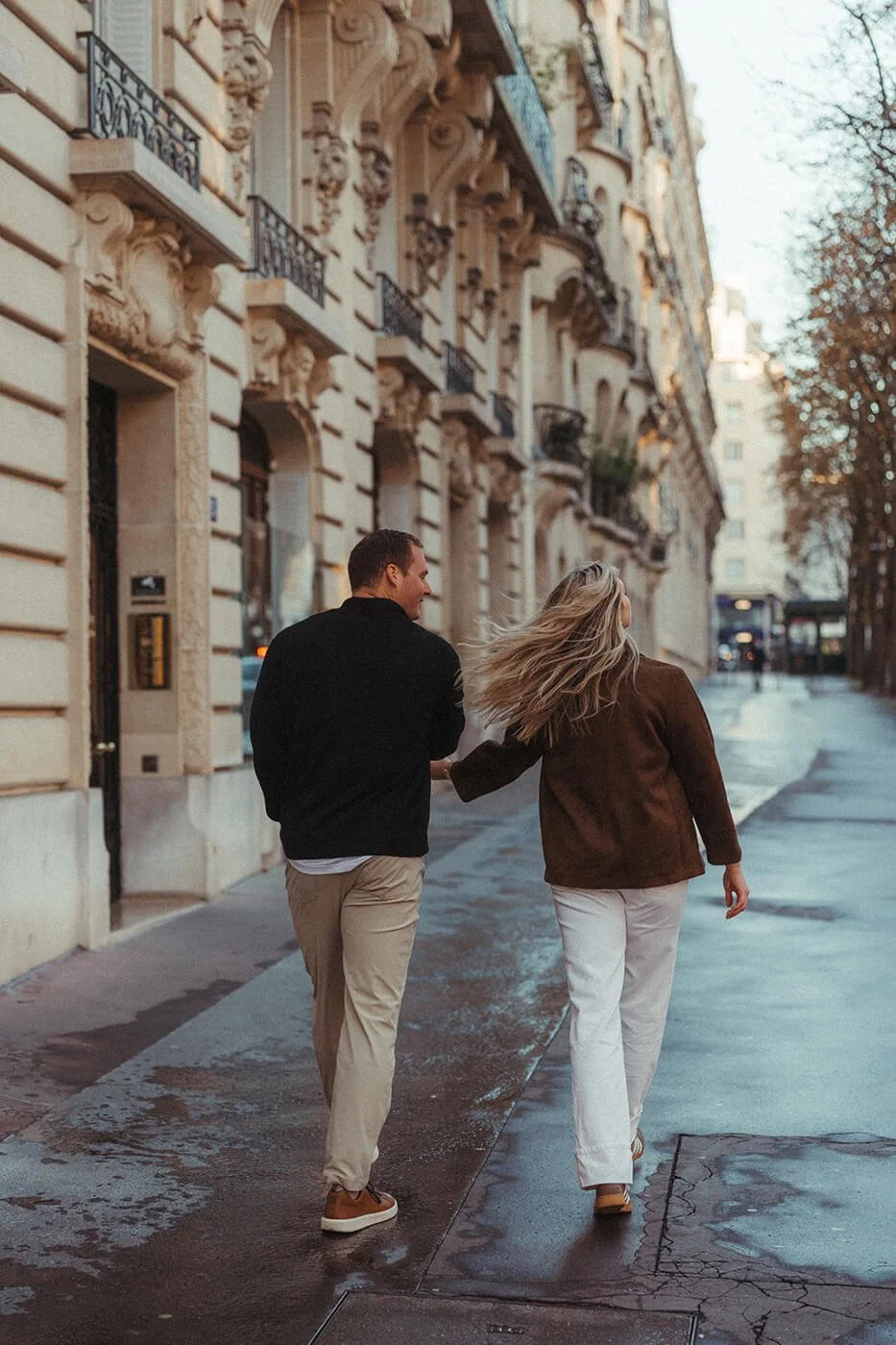 Cinematic couple portrait in warm light with the Eiffel Tower in the background.