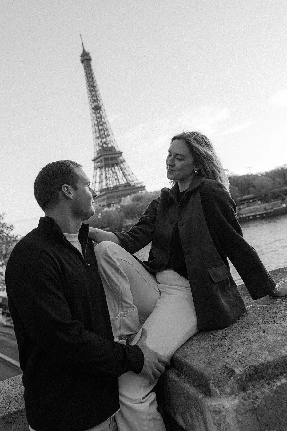 Black and white cinematic couple portrait in Paris with the Eiffel Tower in the background.