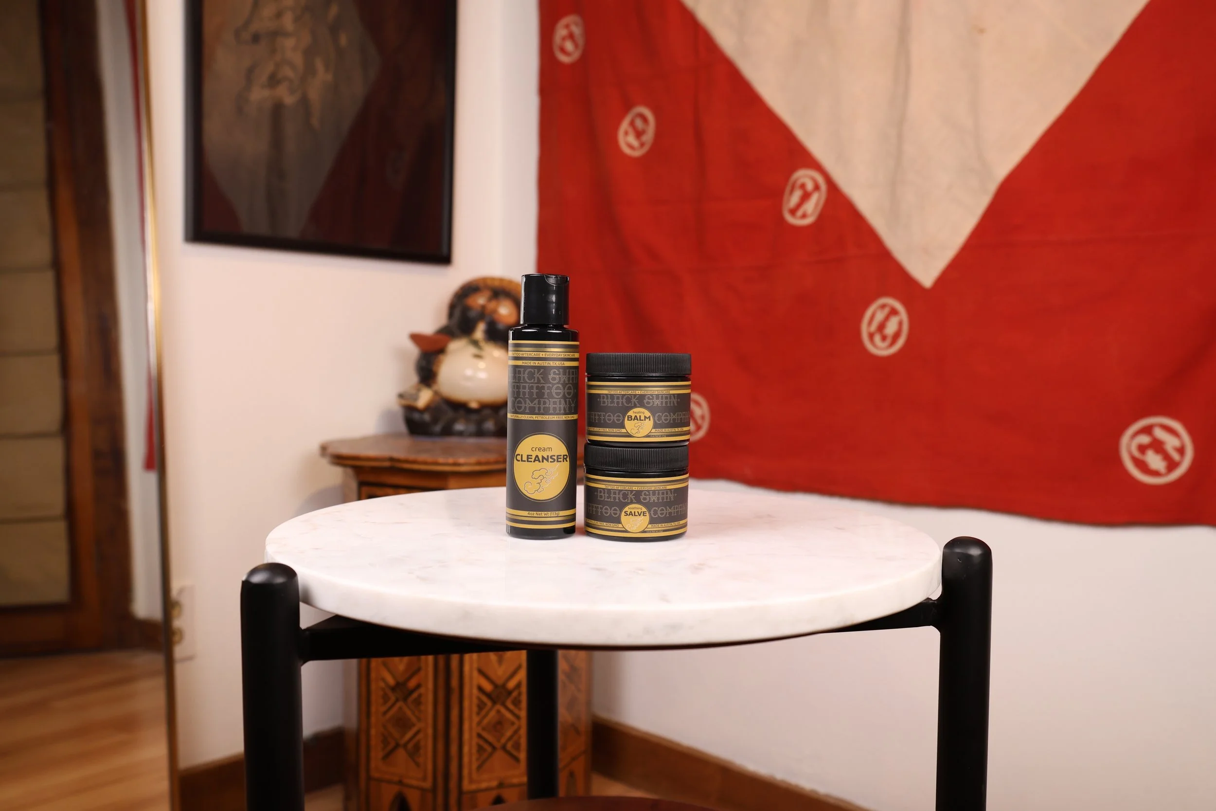 Tattoo aftercare products arranged on marble table minimal studio aesthetic