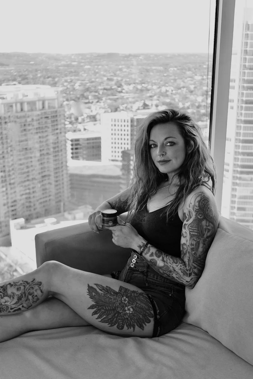 Tattooed client holding aftercare balm natural healed skin lifestyle image