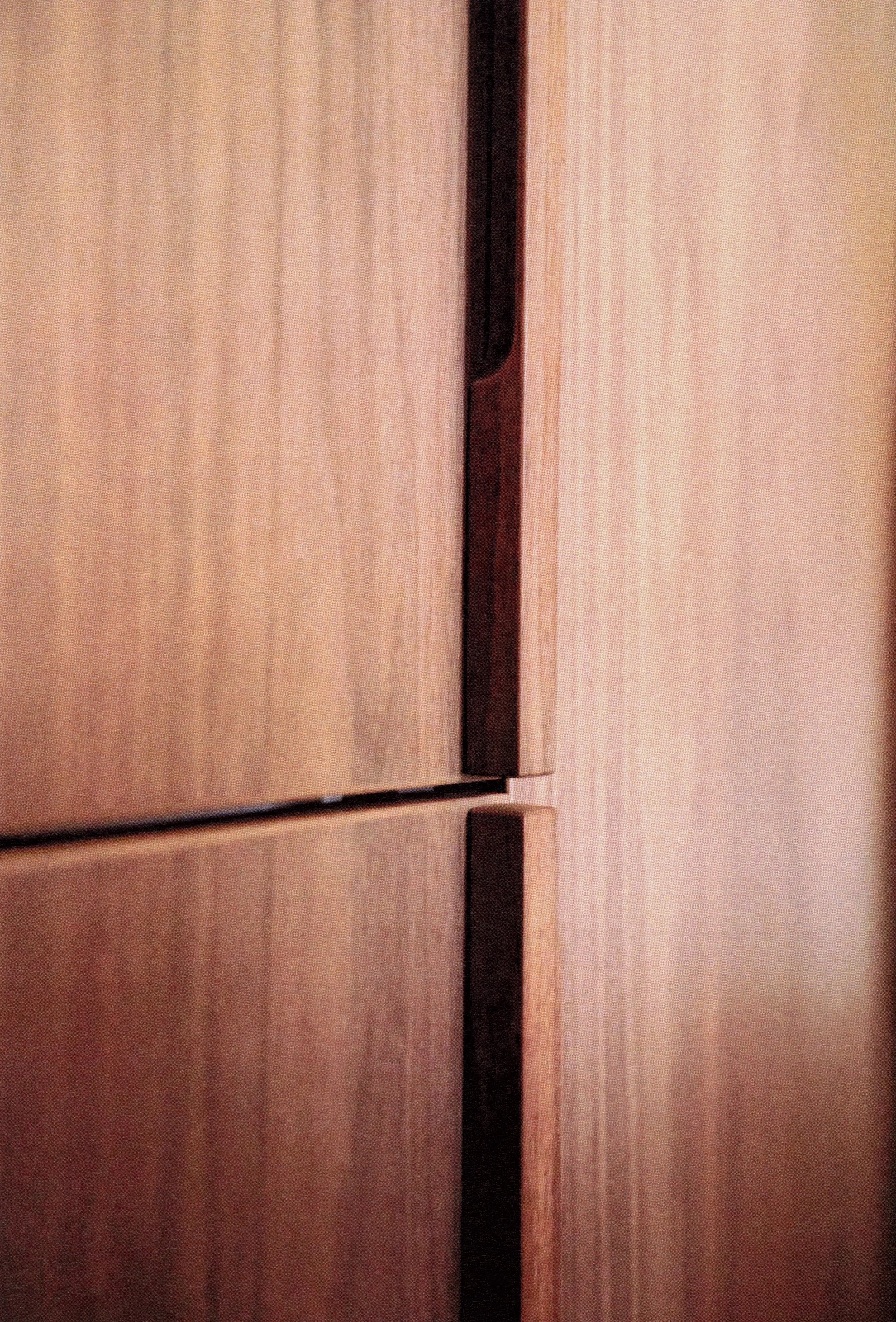Close-up of a set of wooden cupboard doors with a vertical gap between two doors.