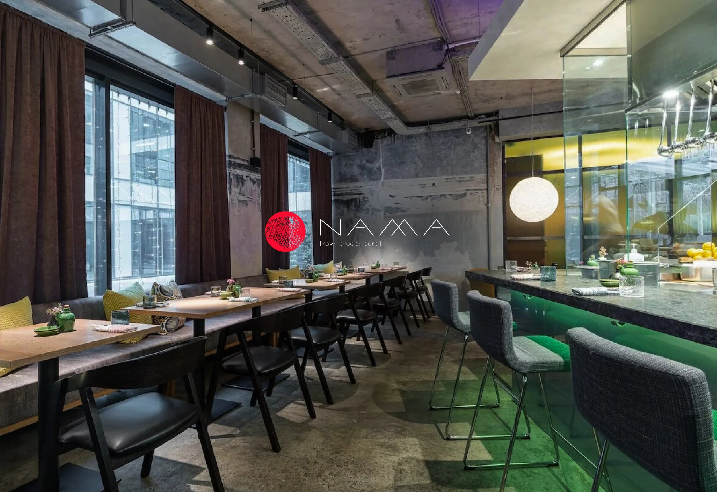 Modern restaurant interior featured in a premium hospitality branding case study, with warm wood finishes, black seating and green upholstered bar stools.